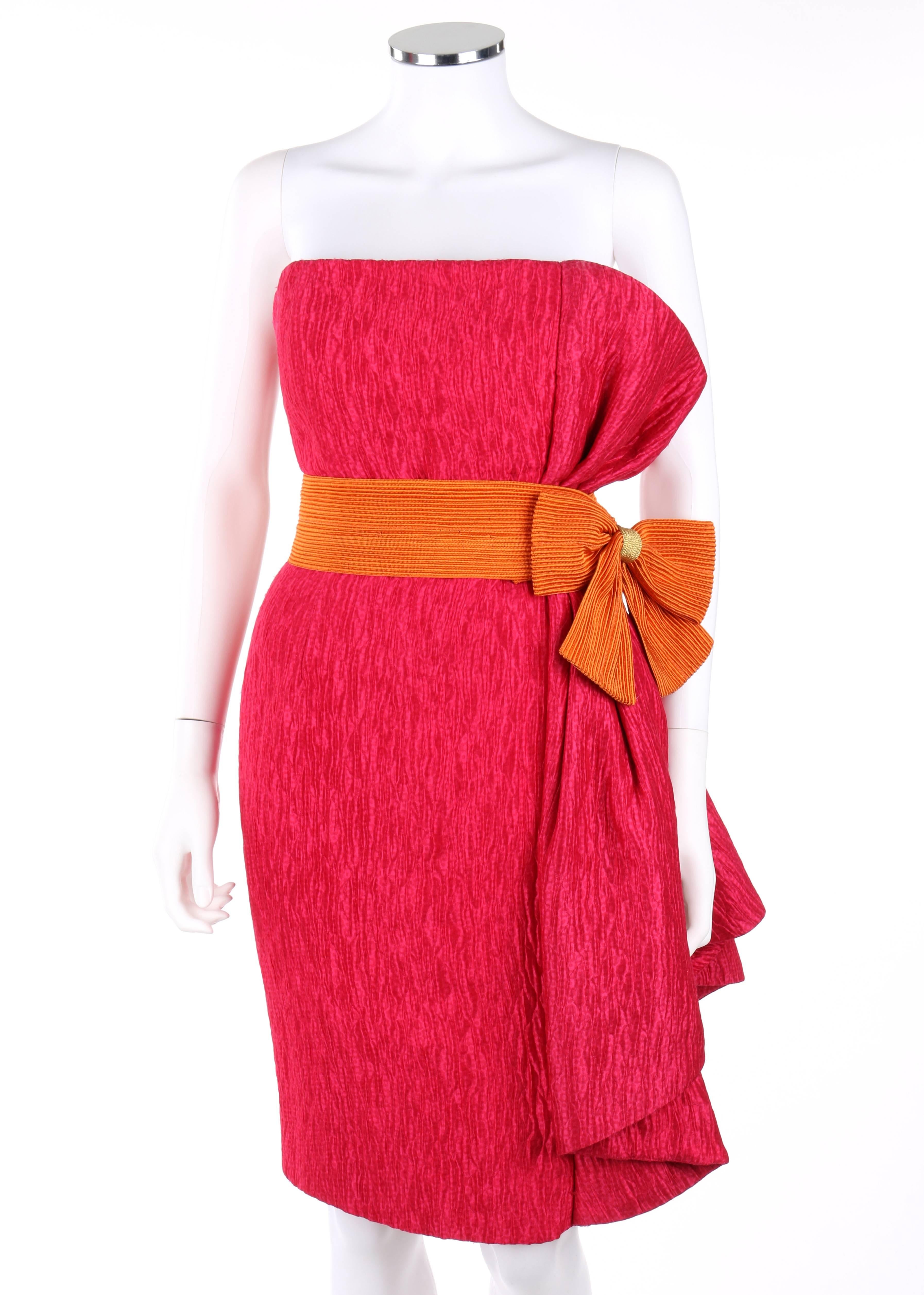 Vintage Pierre Balmain c.1980's bright pink silk strapless cocktail dress. Bright pink quilted animal print silk fabric. Orange rib detail belt with accent bow and velcro closure. Pleated left waistline with dramatic cascading effect and interior