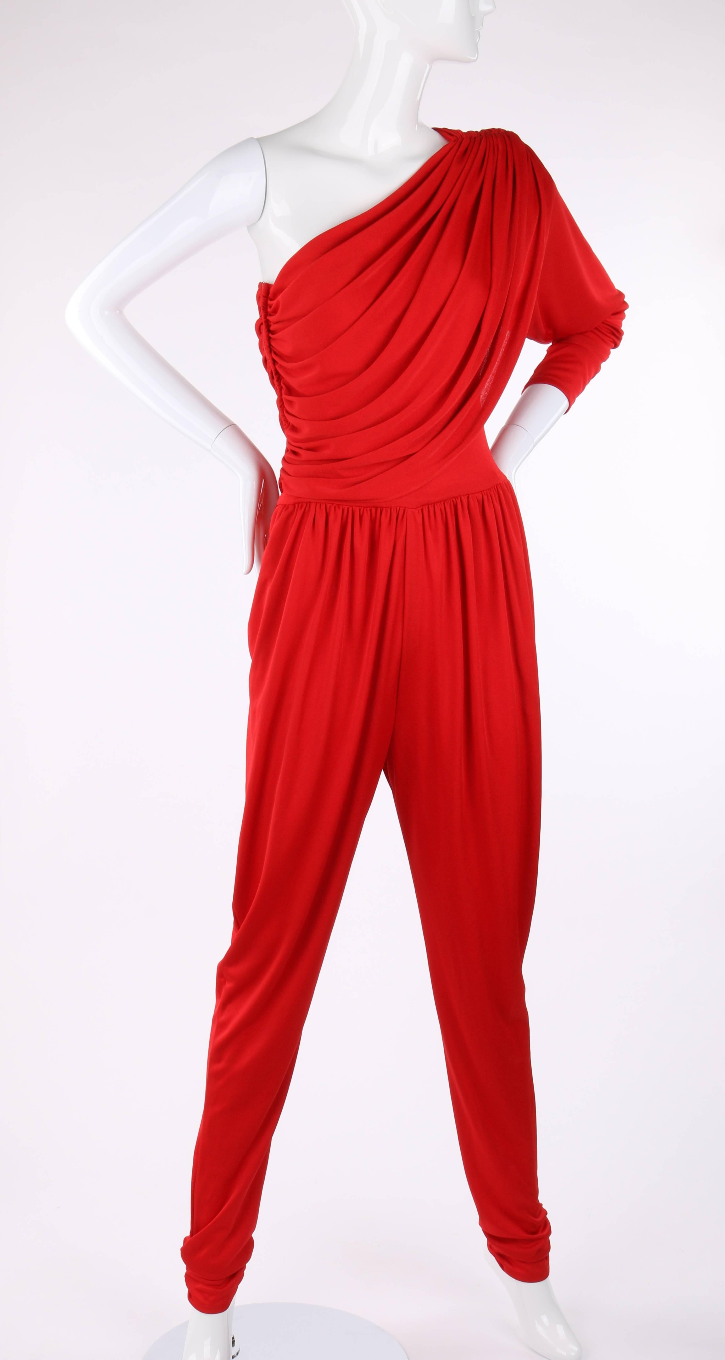 Vintage Halston c.1970's red spandex one shoulder jumpsuit. Right side seam and left shoulder ruched detail creates draped bodice effect. Tapered long sleeve. Side seam zipper closure. Gathered elastic waist band. Two front inseam pockets. Ruched