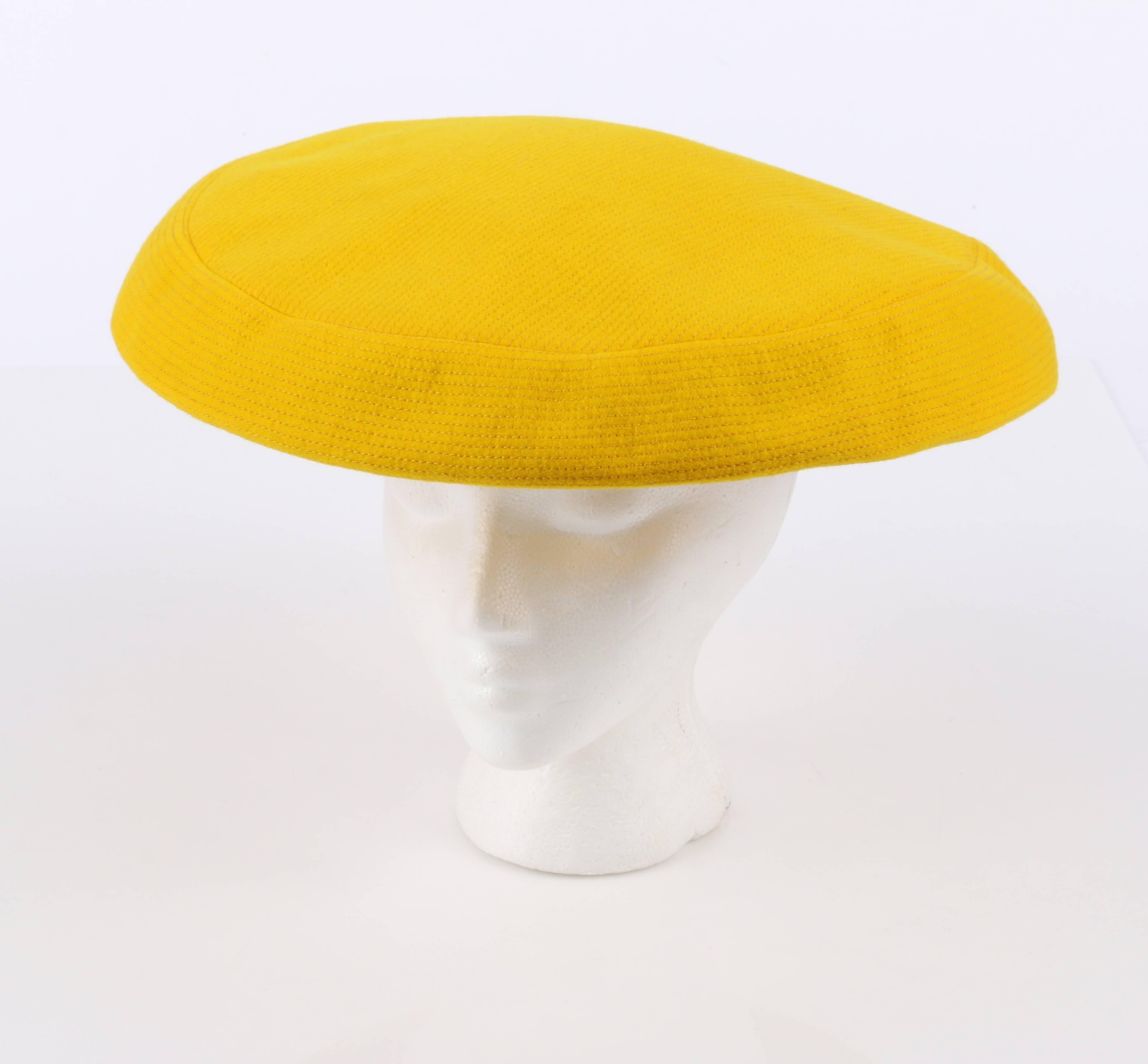 Vintage late c.1960's Yves Saint Laurent for Bergdorf Goodman yellow wool tam style hat. Yellow wool with yellow all over pin stripe top stitch detail. Wide flat top/brim. Two long wool ties with fringed ends. Elastic band at underside for snug fit.