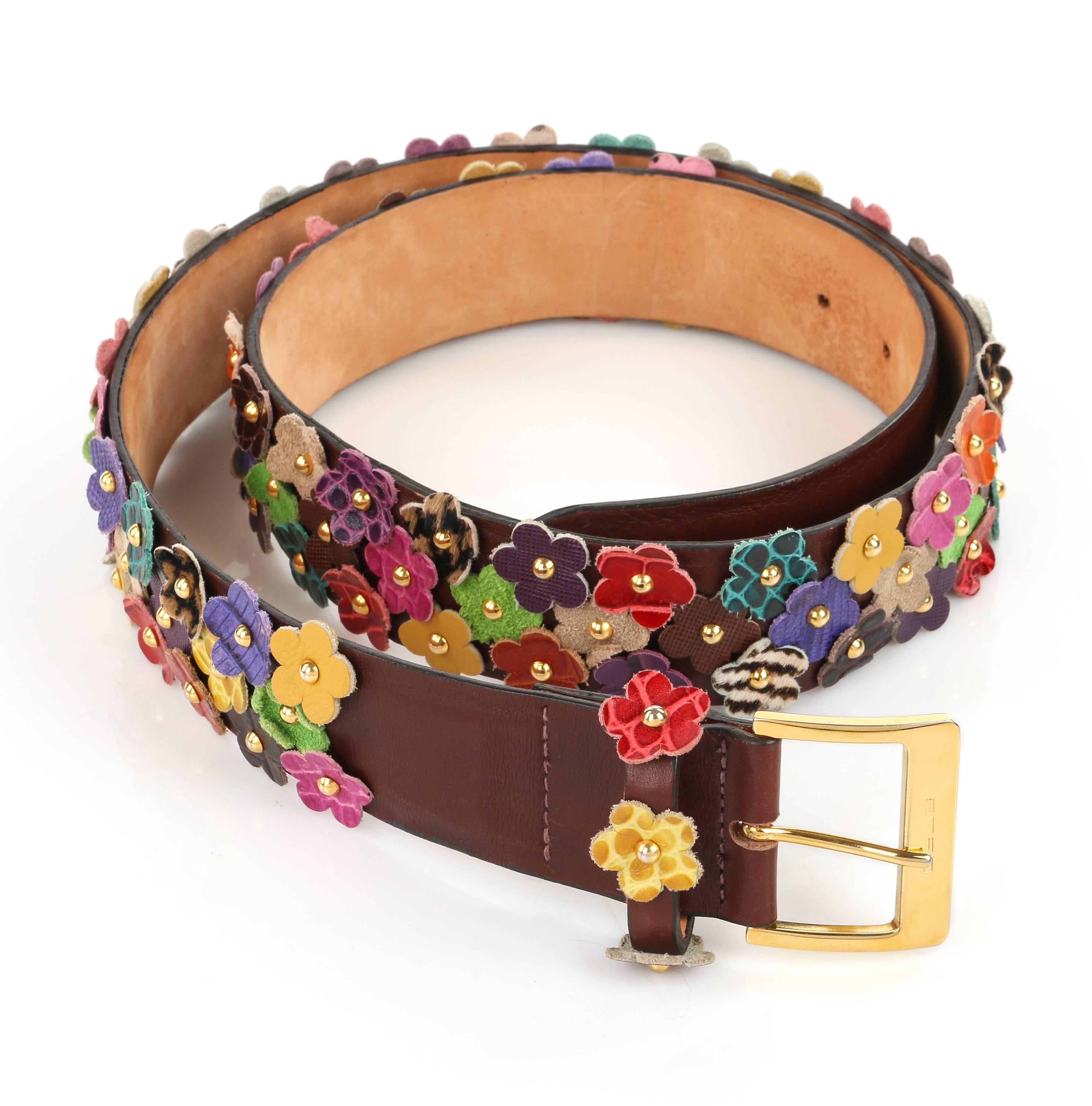 Etro Milano floral studded leather belt. All over leather cut flowers in multiple colors and prints (alligator, lizard suede, saffiano, etc.). Flowers are set into leather belt with gold-toned dome studs. Brown leather belt base. Gold-toned buckle