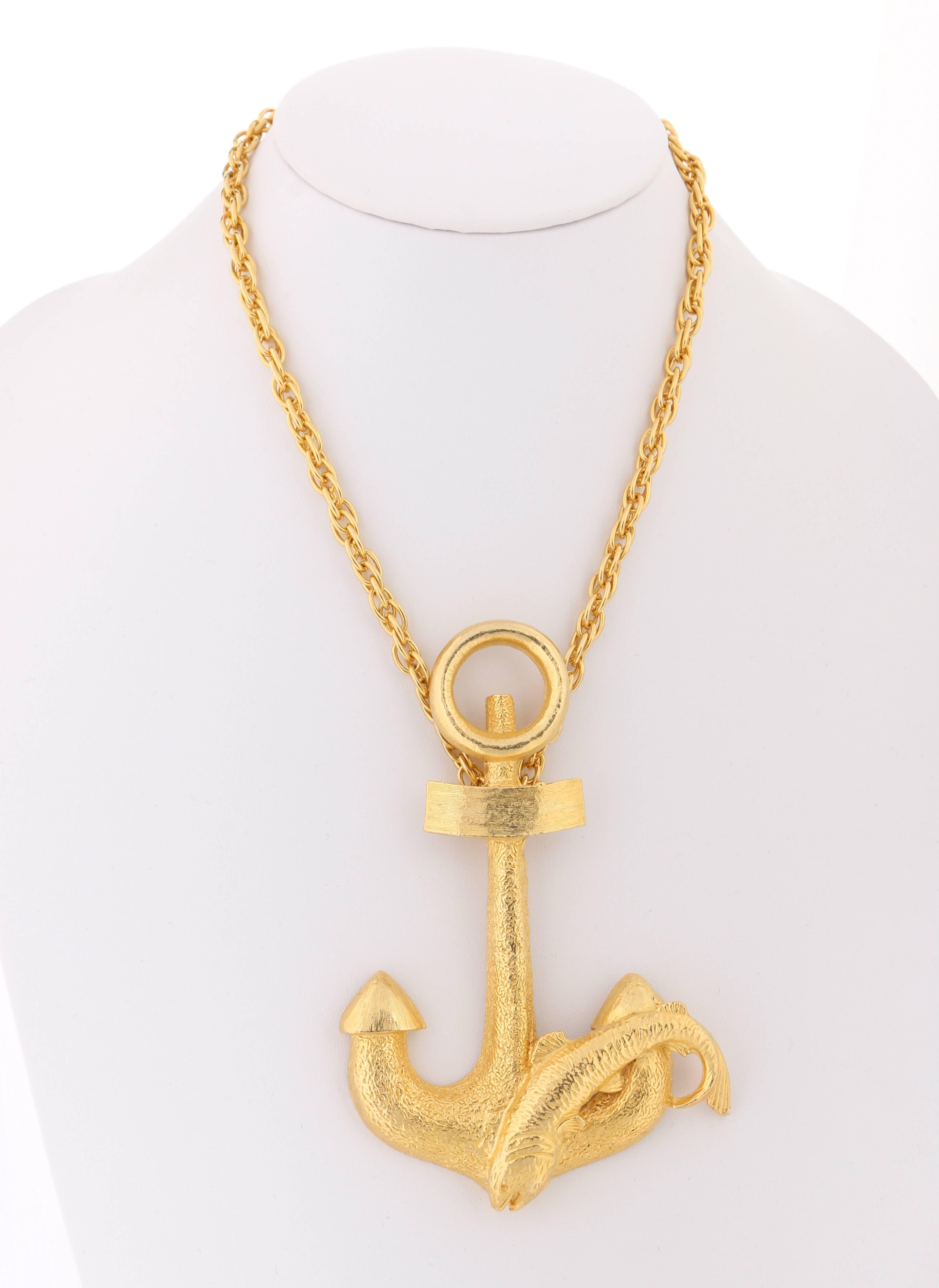 Vintage Hattie Carnegie c.1970's large anchor pendant statement necklace. Large gold-toned etched metal anchor pendant with integrated fish. Pendant is suspended by a polished gold-toned short prince of wales chain. Necklace fastens with a spring