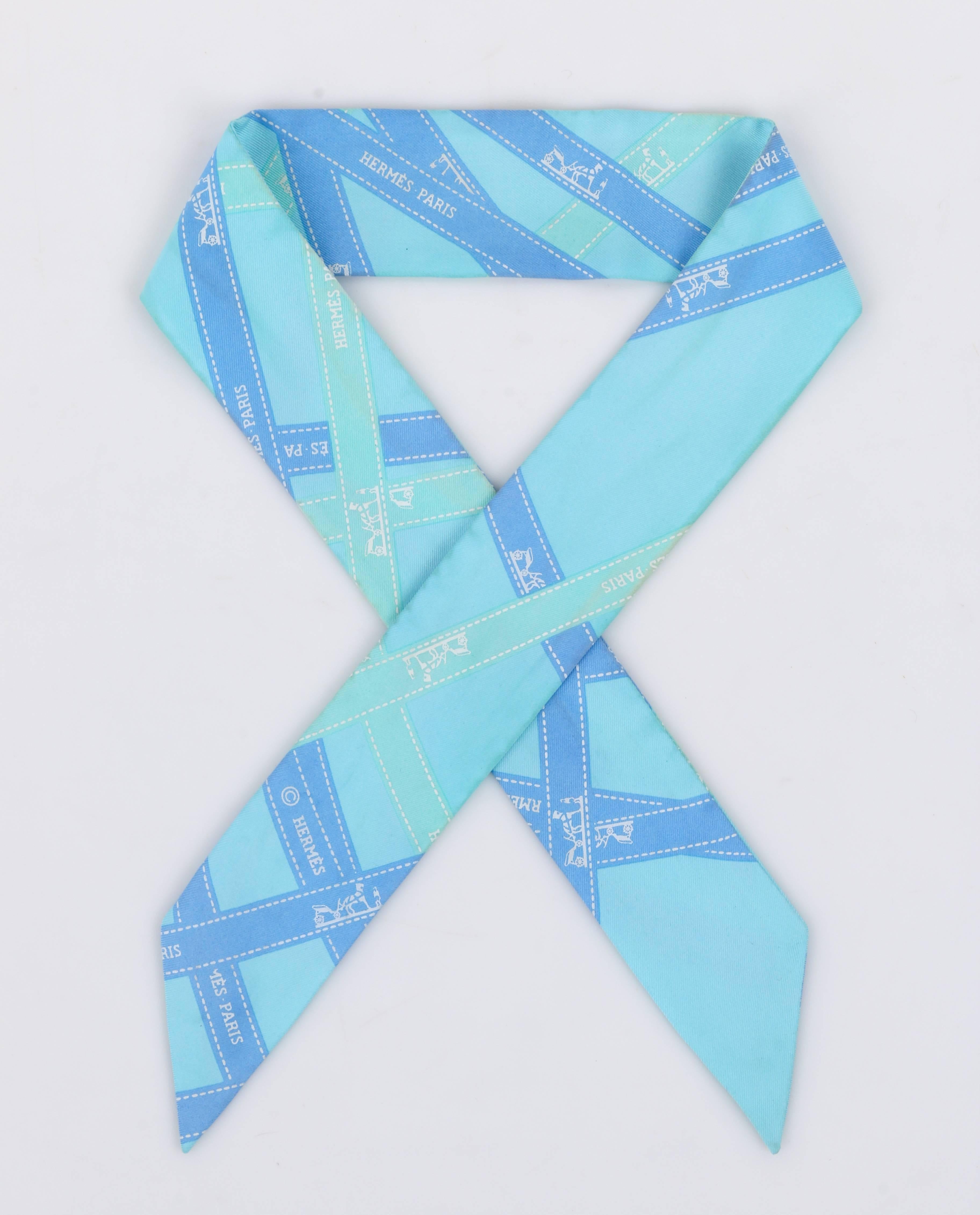 Hermes "Twilly" turquoise silk skinny scarf / neck tie. Hermes "Bolduc" (ribbon) print in shades of blue and aqua. Angled cut ends. Marked Fabric Content: "100% Silk". Measurements:

Length: 33"
Width: 1.875"