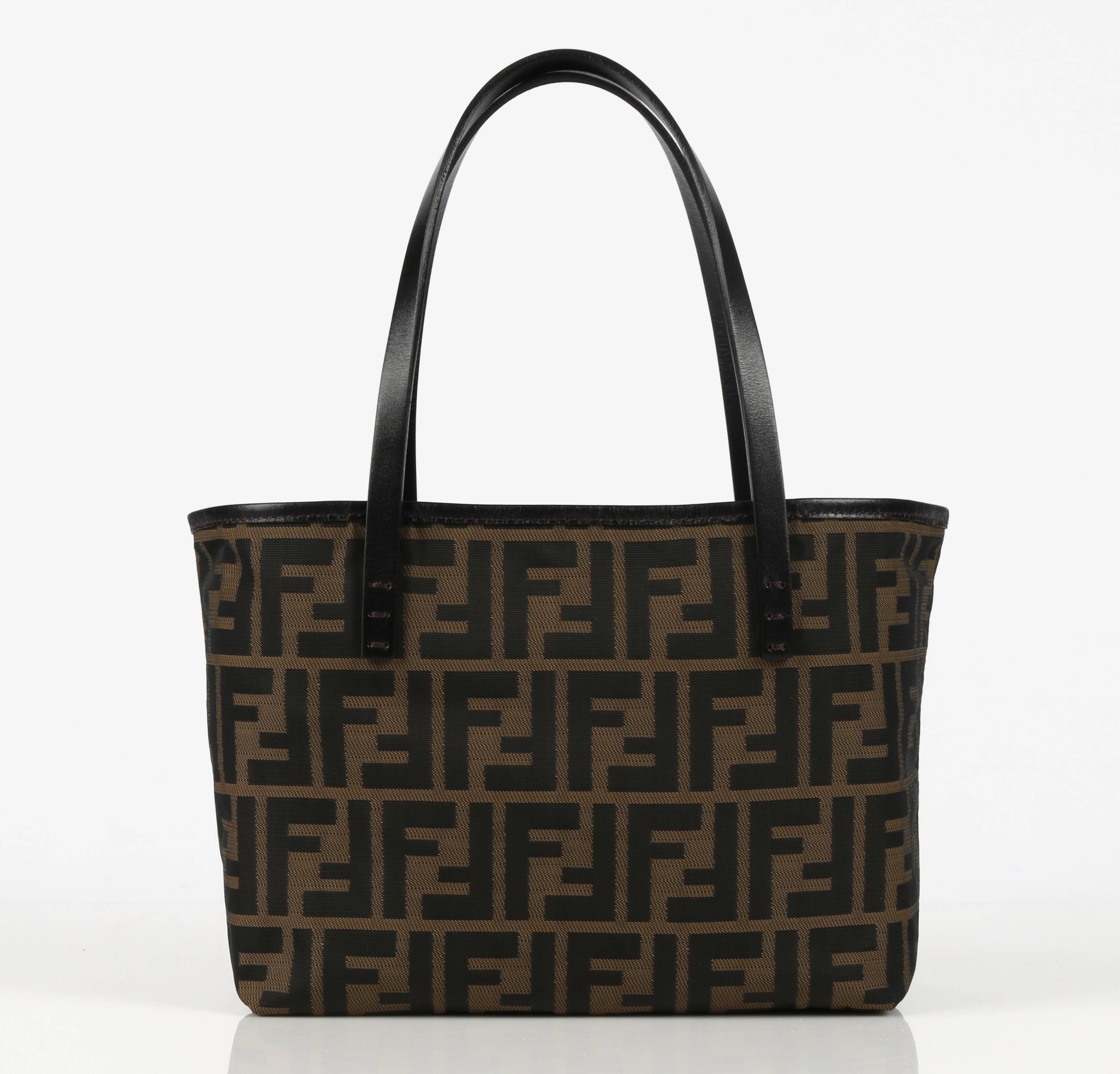 Fendi brown tobacco canvas & genuine leather Zucca print "Roll" tote bag. Brown signature "FF" Zucca print body. Brown leather trim and handles. Open top. Matching zip top coin purse attached to interior via thin leather