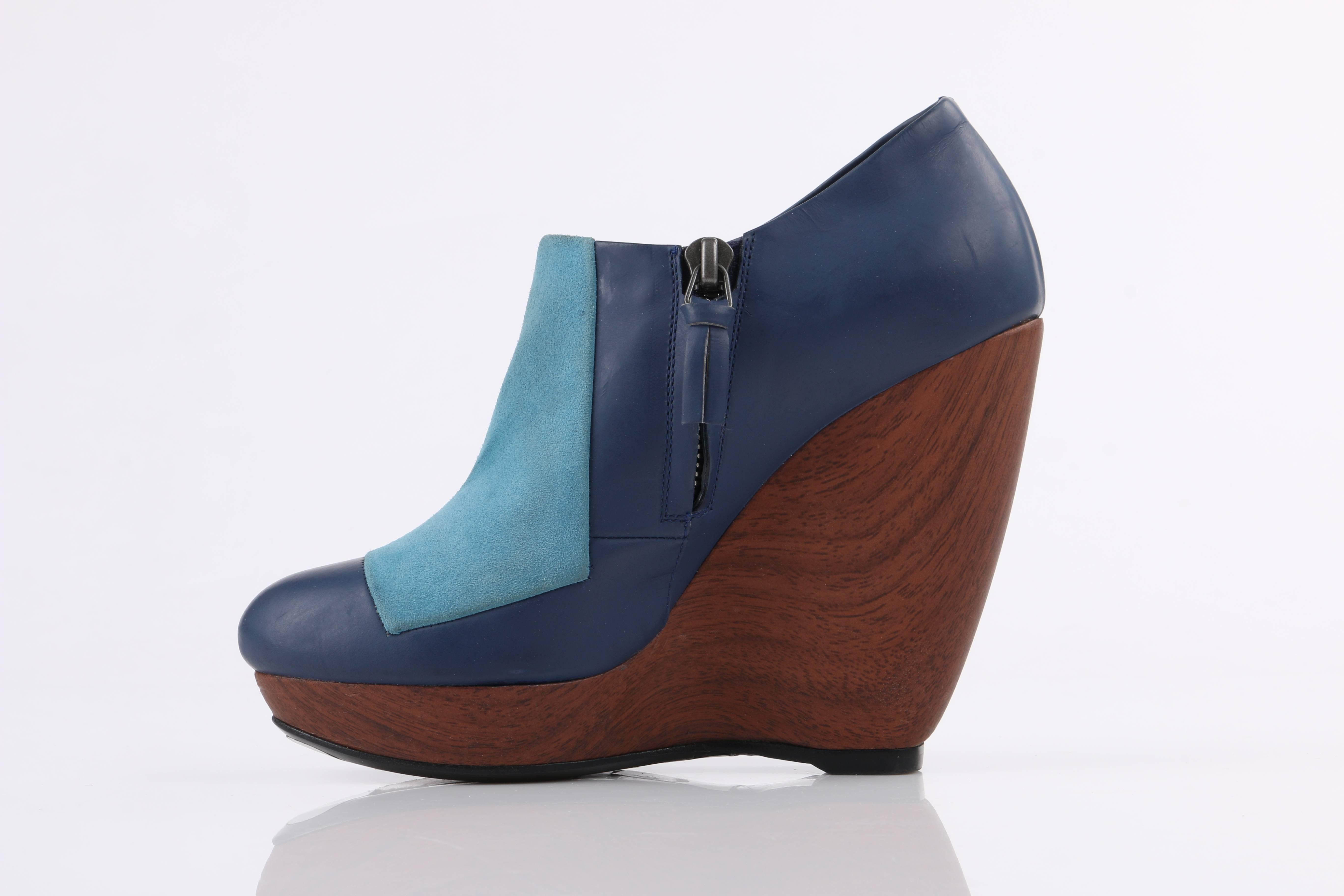 Balenciaga light on dark blue colorblock wooden wedge heels. Blue matte finish genuine leather upper with light blue suede front panel. Side zip closure with navy leather zipper pull. Leather lined. Brown wooden platform wedge. Black leather sole.
