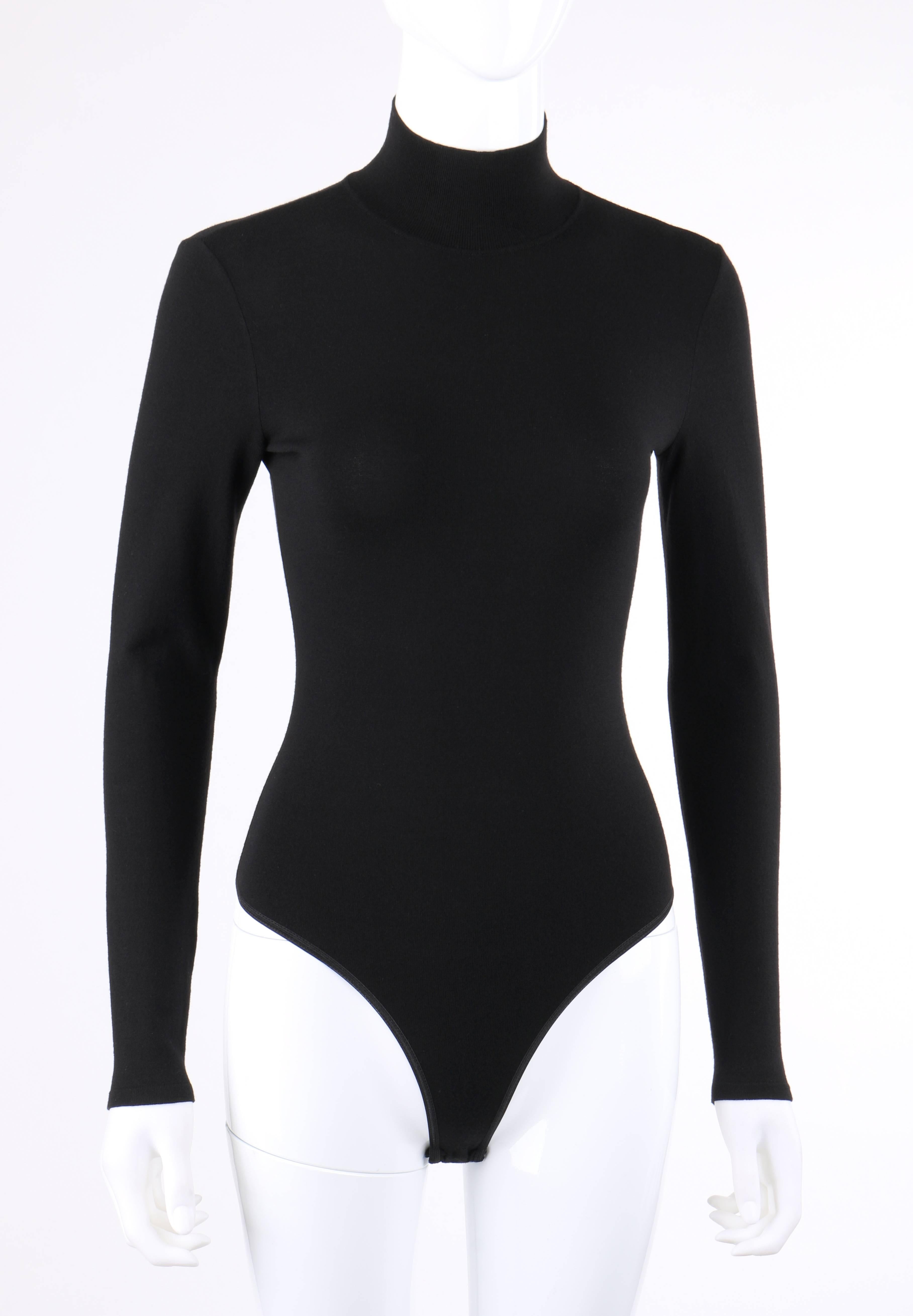 Alaia Paris black wool blend knit bodysuit; New without tags. Rib knit mock neck. Long sleeves. Elasticized high cut leg holes with thong back. Three snap closures at crotch. Pull over style. Marked Fabric Content: 