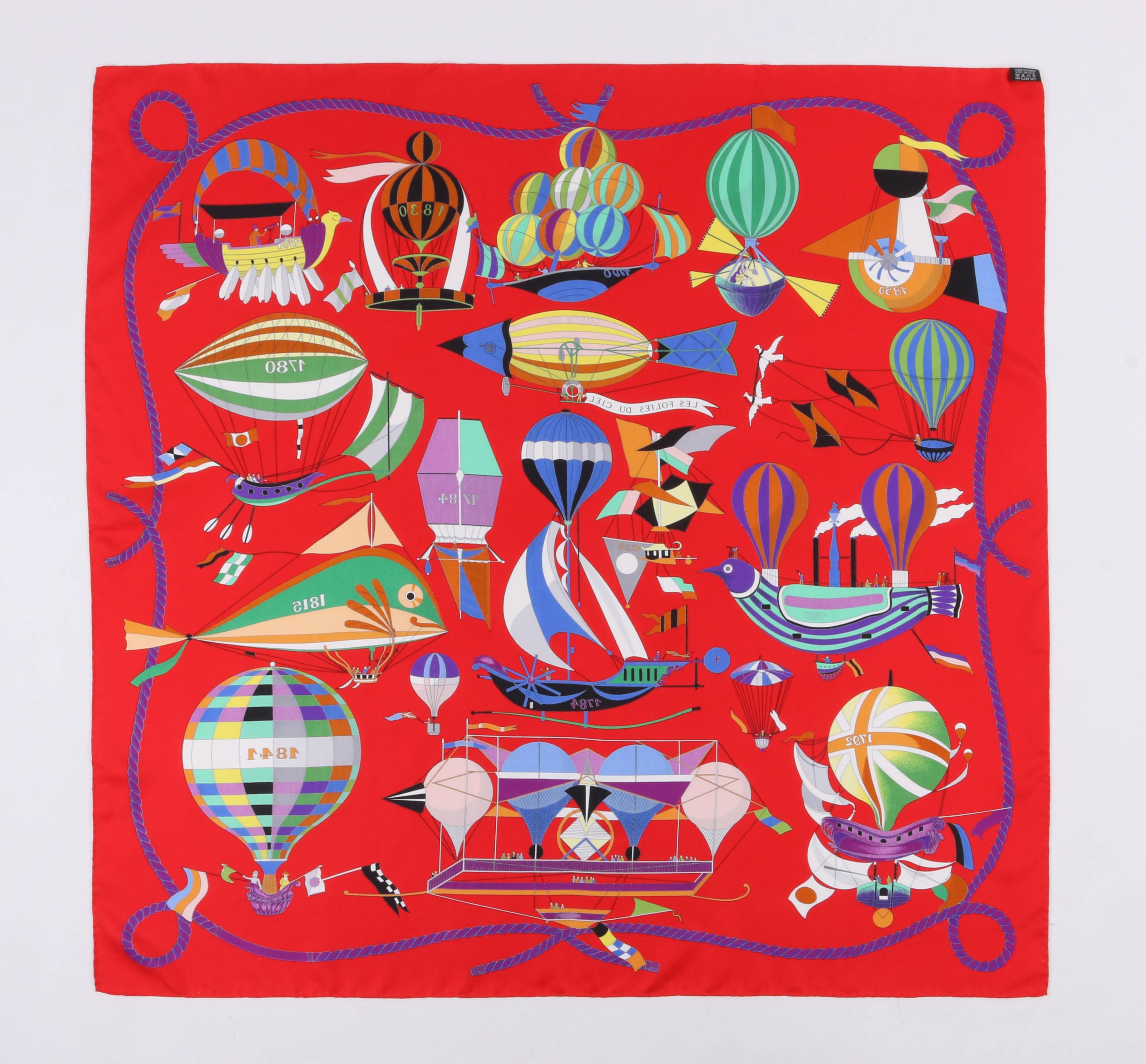 Hermes Spring/Summer 2009 "Les Folies Du Ciel" silk twill scarf designed by Loic Dubigeon. Original scarf design released in 1984. Red background with purple rope boarder print. Bright multi-color vintage flying machines marked with their