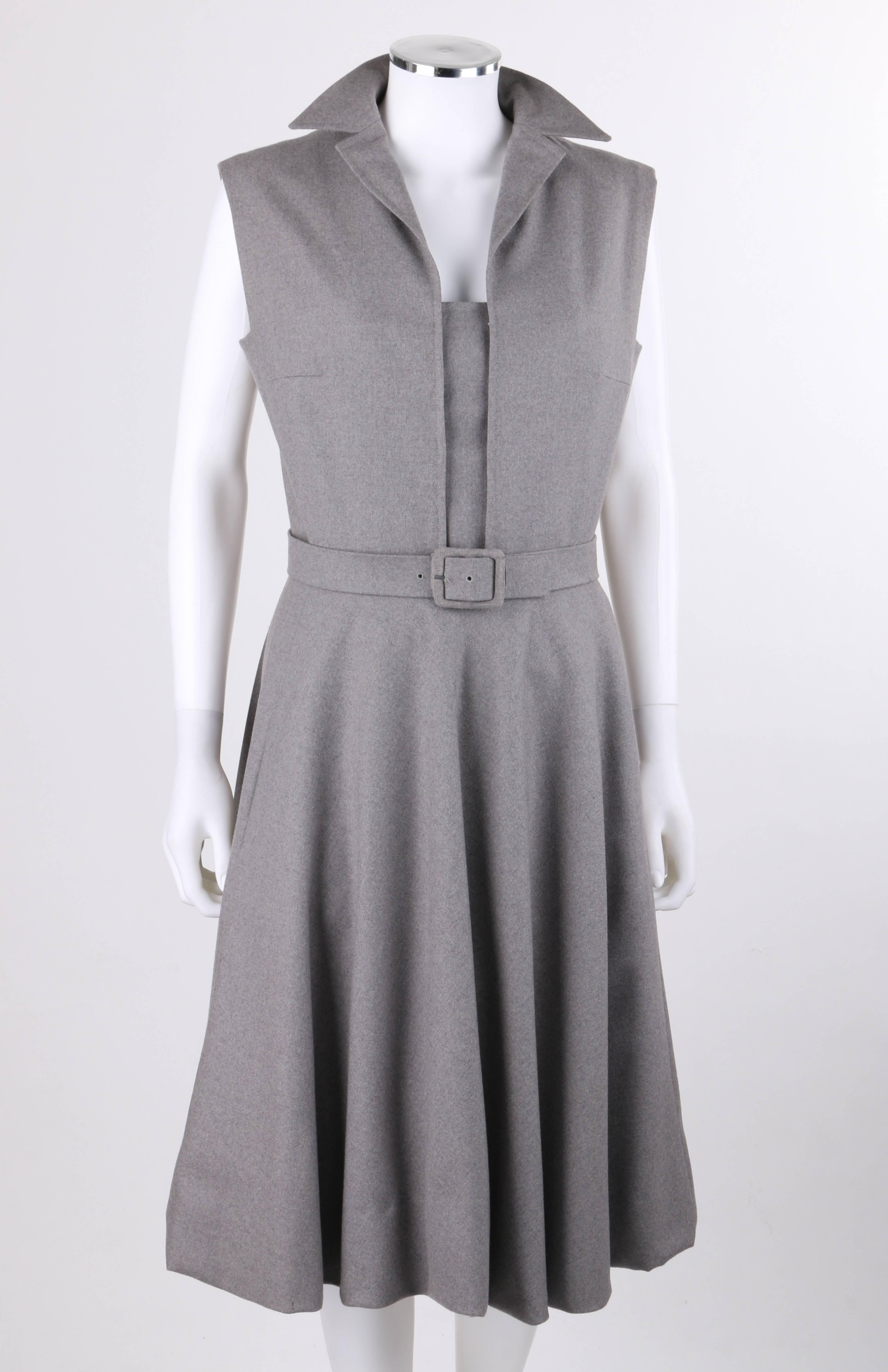 Vintage Pauline Trigere c.1980's gray wool belted day dress. Extended shoulder bodice with square cut arm holes. Notched lapel collar. Center front removable modesty panel with five snap closures on either side. Two front inseam hip pockets. Two
