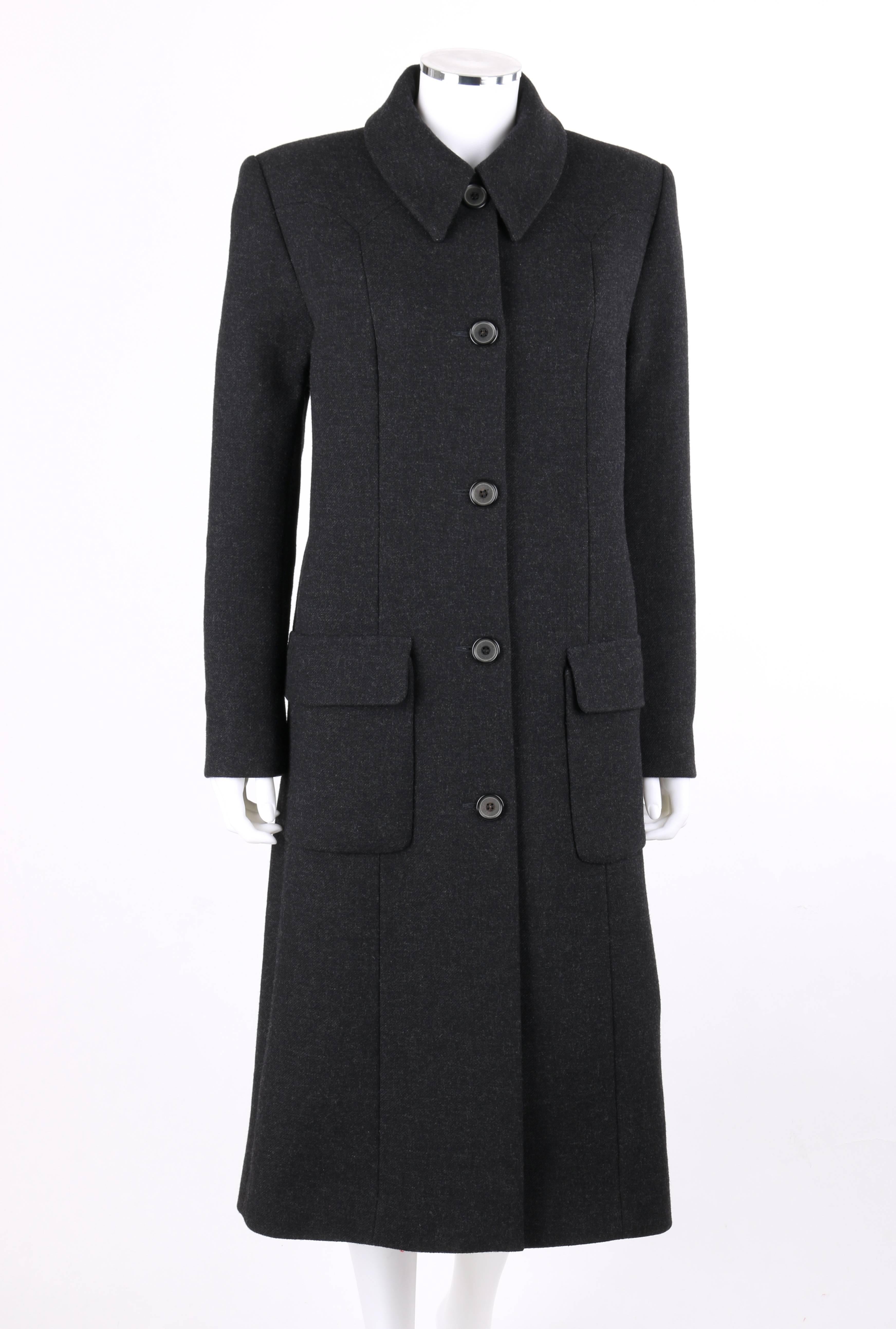 Manteau Givenchy Couture automne/hiver 1998 en laine gris anthracite conçu par Alexander McQueen. Manches longues. Collier de bal. Cinq boutons centraux sur le devant et un bouton-pression sur le dessus. Empiècement frontal en pointe. Deux grandes