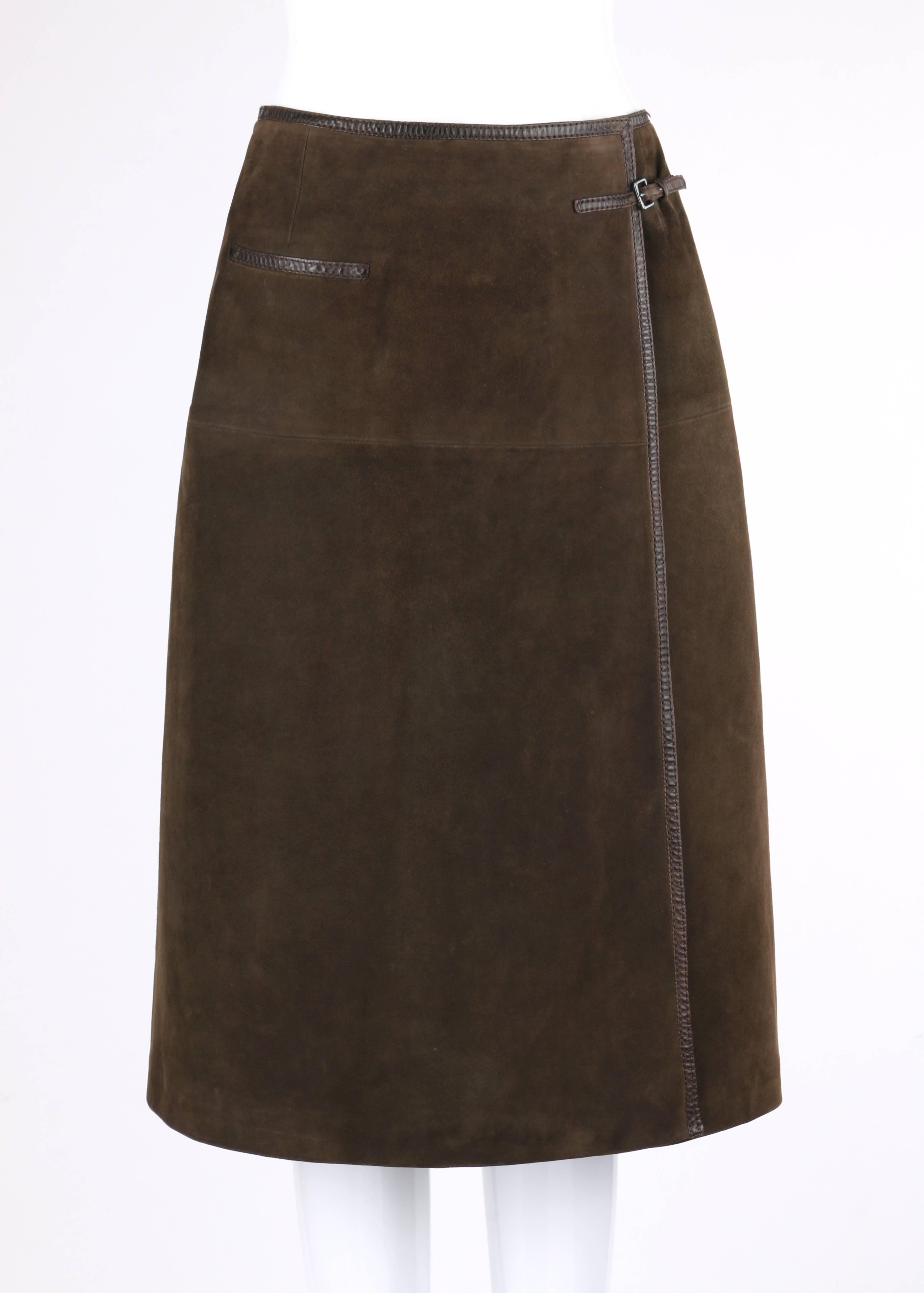 Vintage Hermes Sport c.1970's brown suede leather wrap skirt. Three panel wrap skirt. Adjustable leather strap with antique nickel-toned metal buckle closure. Single interior and single exterior hook and loop closures at waistline. One single welt