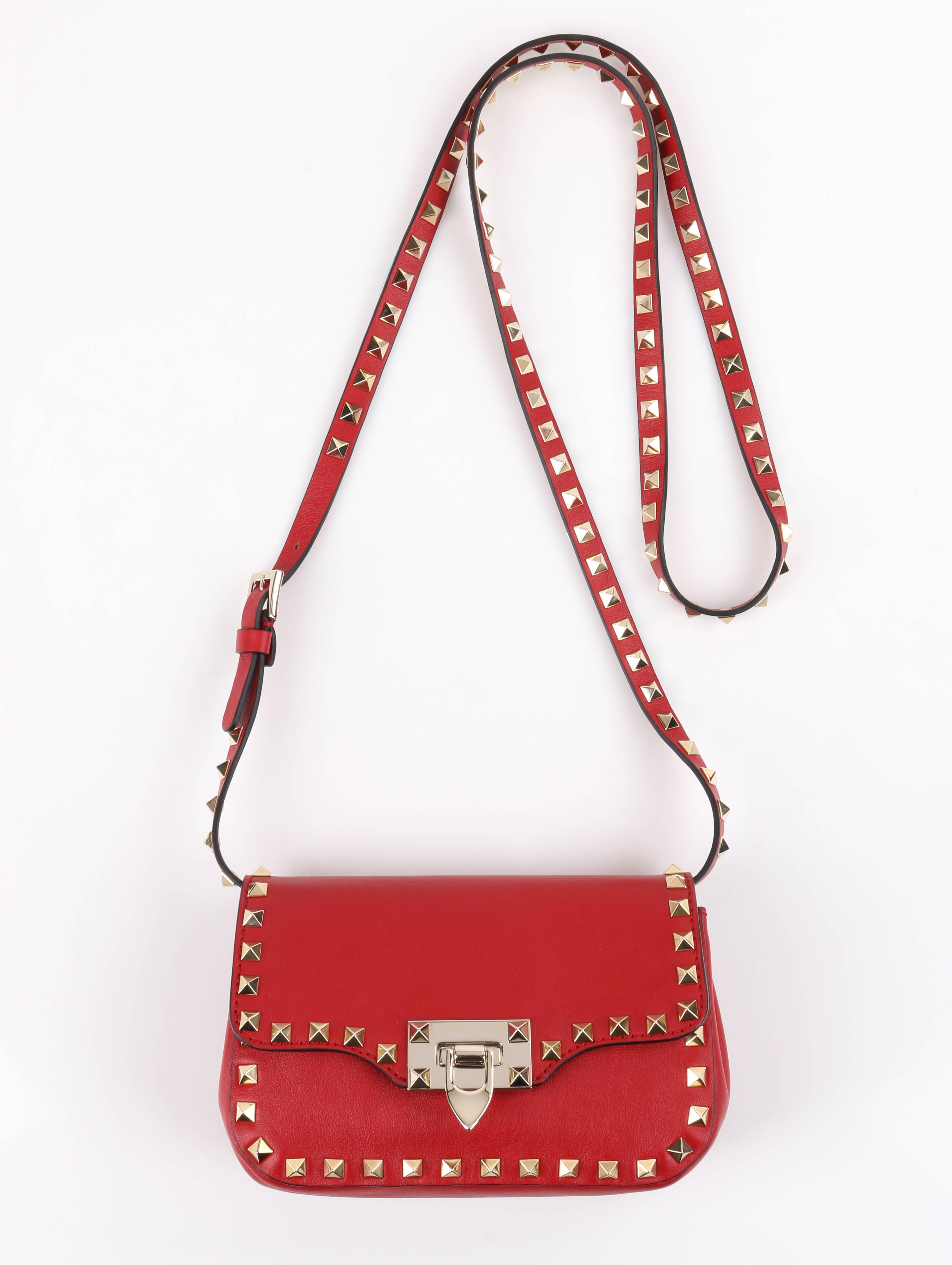 Valentino Garavani red vitello (calf) leather and gold pyramid stud "Mini Rockstud" cross-body purse. Flap top with gold-toned flip-lock closure. Gusseted sides. Long adjustable and detachable thin cross-body strap with gold-toned buckle