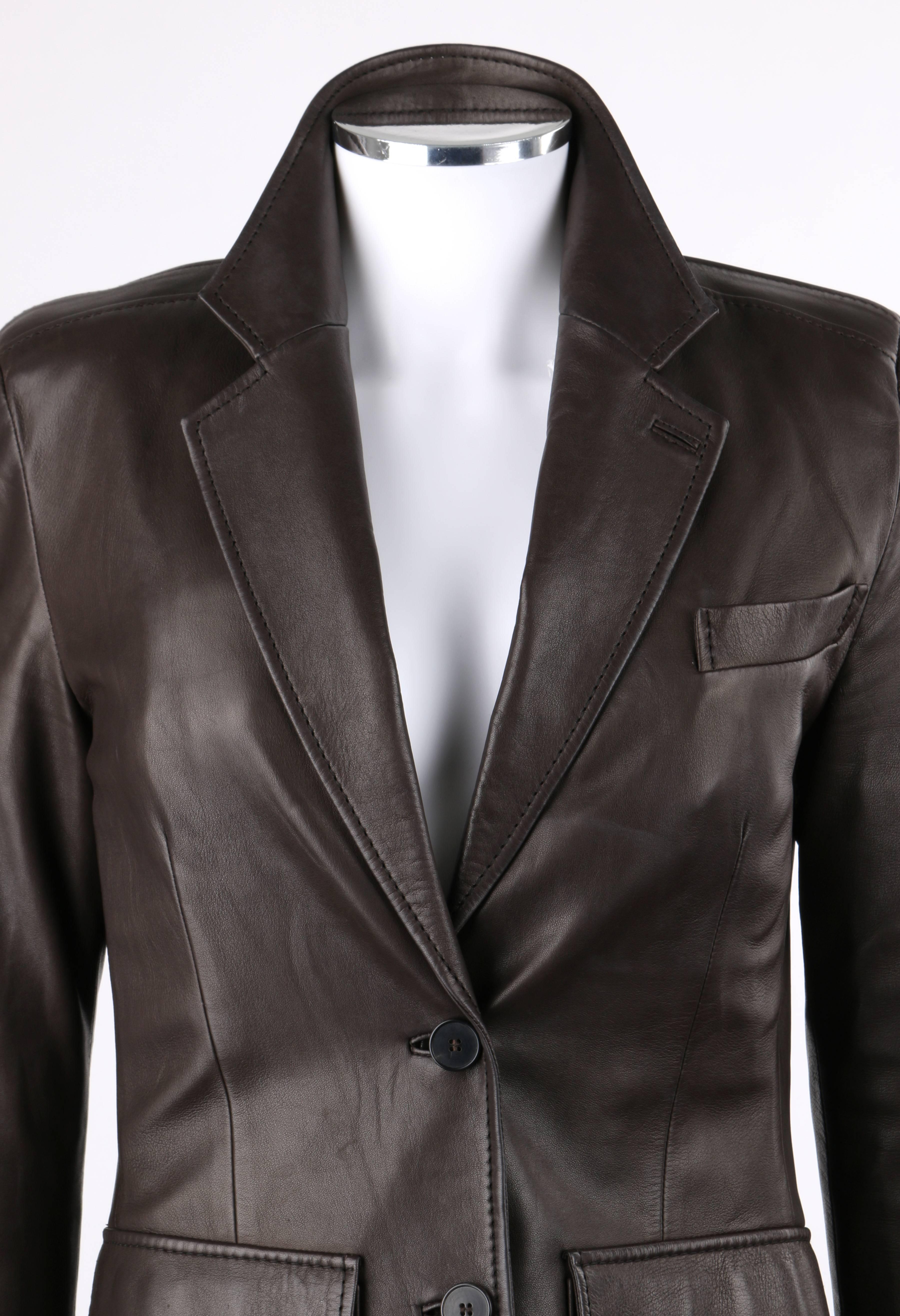Yves Saint Laurent YSL brown leather two button blazer. Notched lapel collar with single button hole detail at lapel. Long sleeves with inset panel from neckline to cuff and four hidden button closures at cuff. Two center front button closures. Two