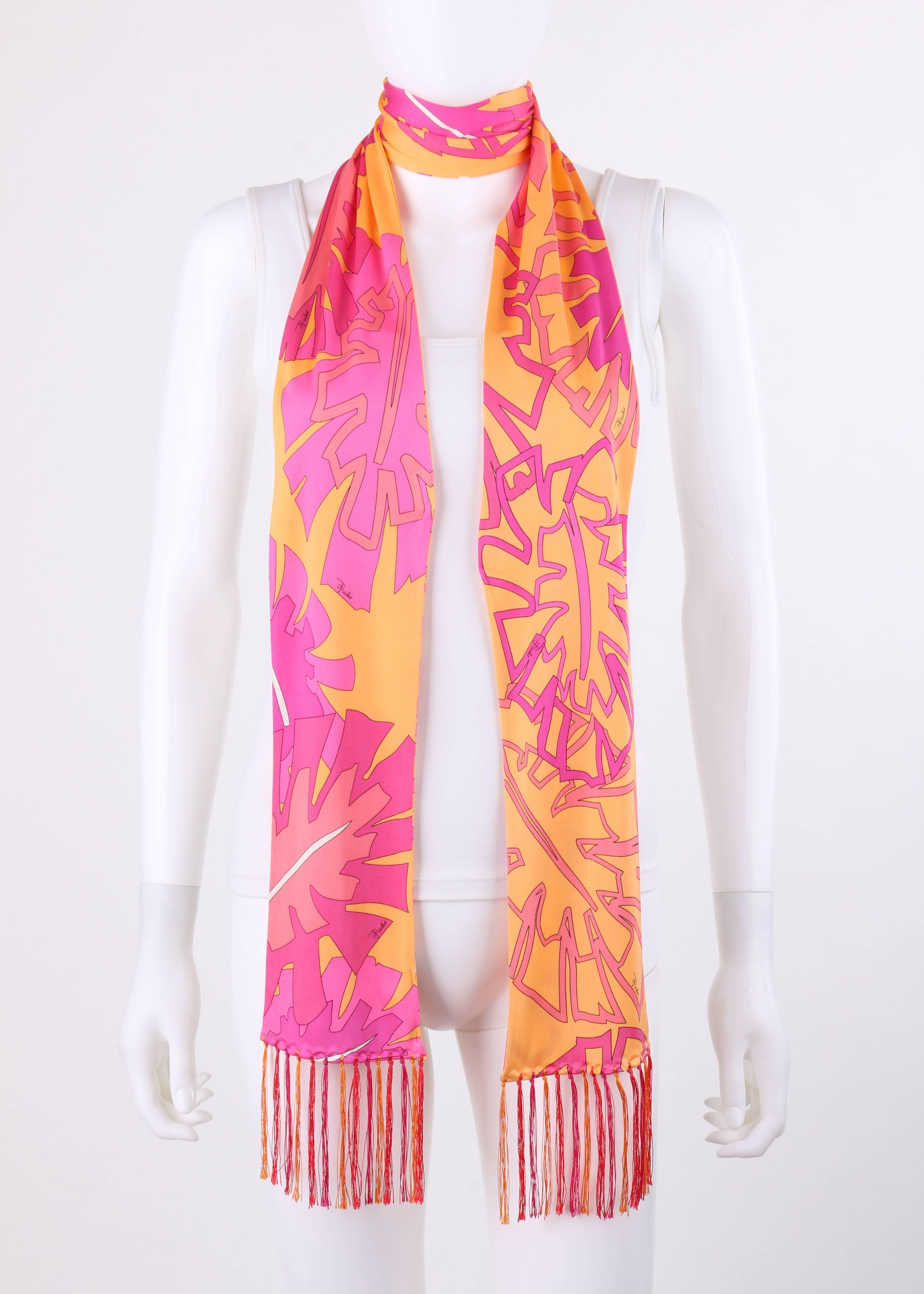 Emilio Pucci orange and pink signature leaf print silk jersey oblong fringe scarf. Multi-color signature botanical leaf print in shades of fuchsia, magenta, pink, and white on orange. Thin oblong style. Fringe detail at both ends in shades of