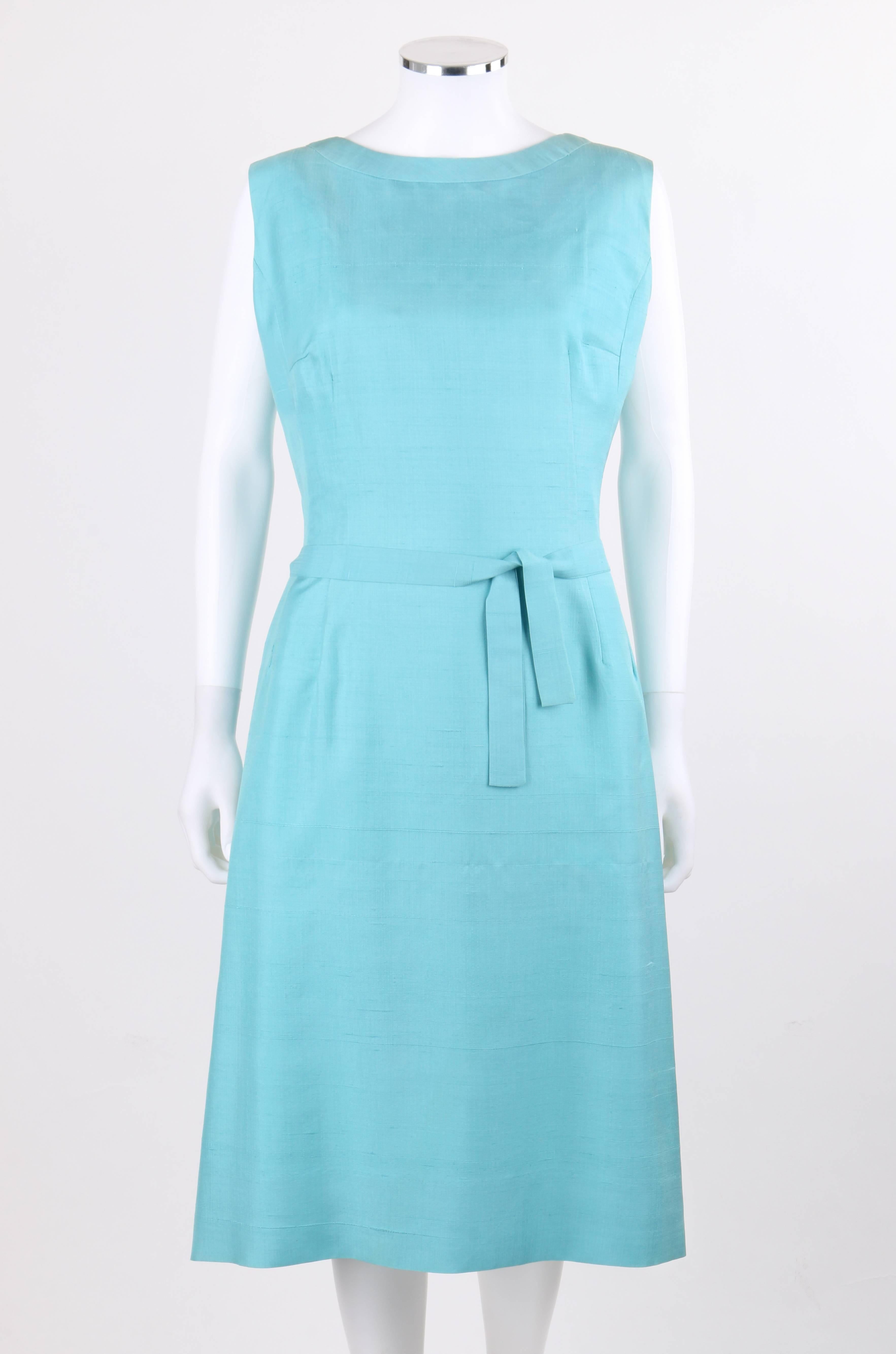 Vintage Pierre Cardin early 1960's aquamarine blue raw silk knife-pleated shift dress with belt designed in Paris for Miss Bonwit. Banded bateau neckline. Sleeveless. Shift style. Back knife-pleated attached overlay. Gathered waistline at back.