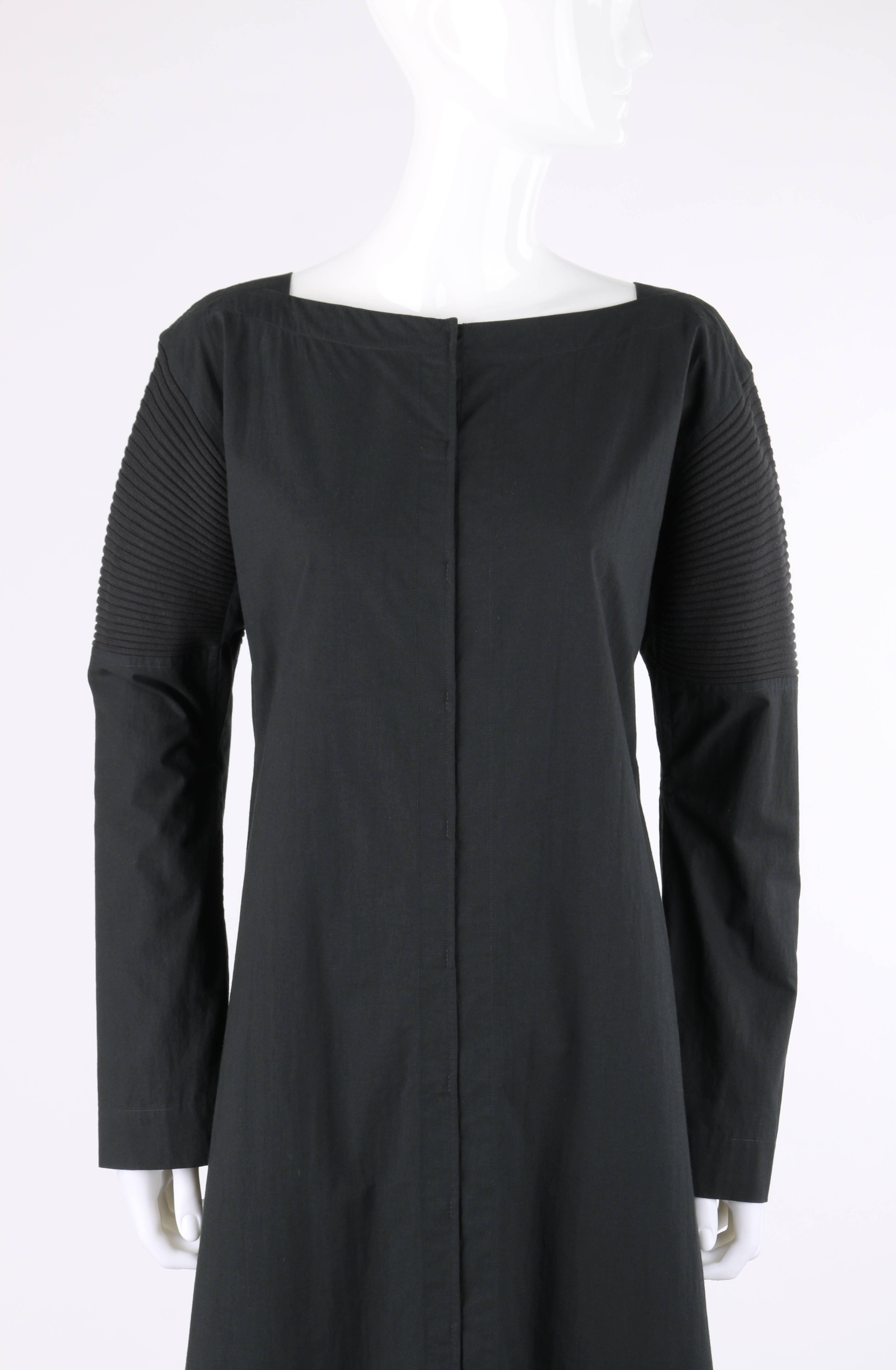 Issey Miyake black cotton rib knit detail long sleeve full length coat dress. Square bateau neckline. Drop shoulder. Long sleeves with rib knit panel from shoulder to elbow. Underarm gussets. Twelve center front concealed hook and loop closures.