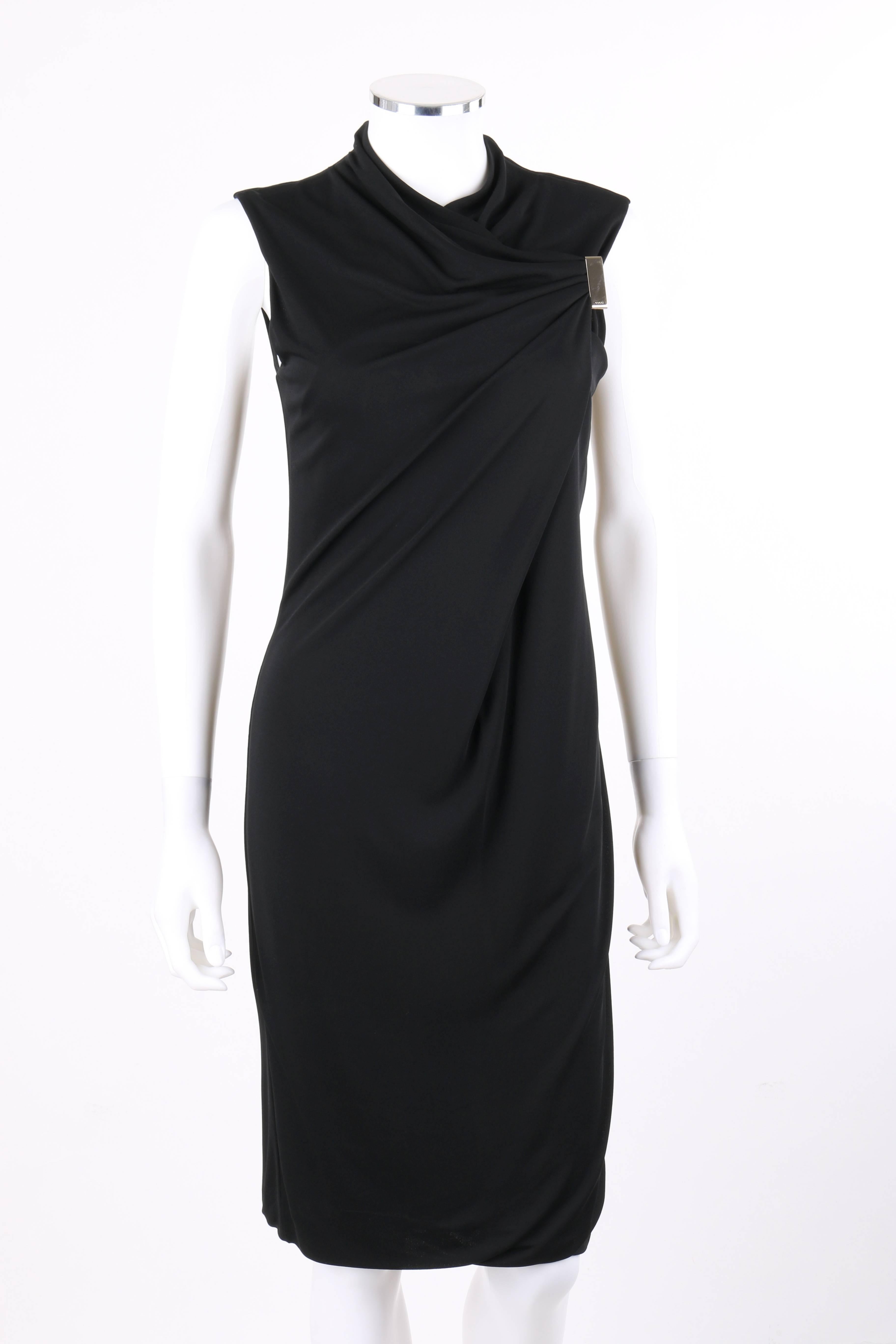 Gucci black jersey knit sleeveless draped shift cocktail dress. Crew neckline. Front crisscrossed drape detail with rectangular gold-toned metal brooch.  Sleeveless. Shift style. Center back invisible zipper with hook and eye closure at top. Fully