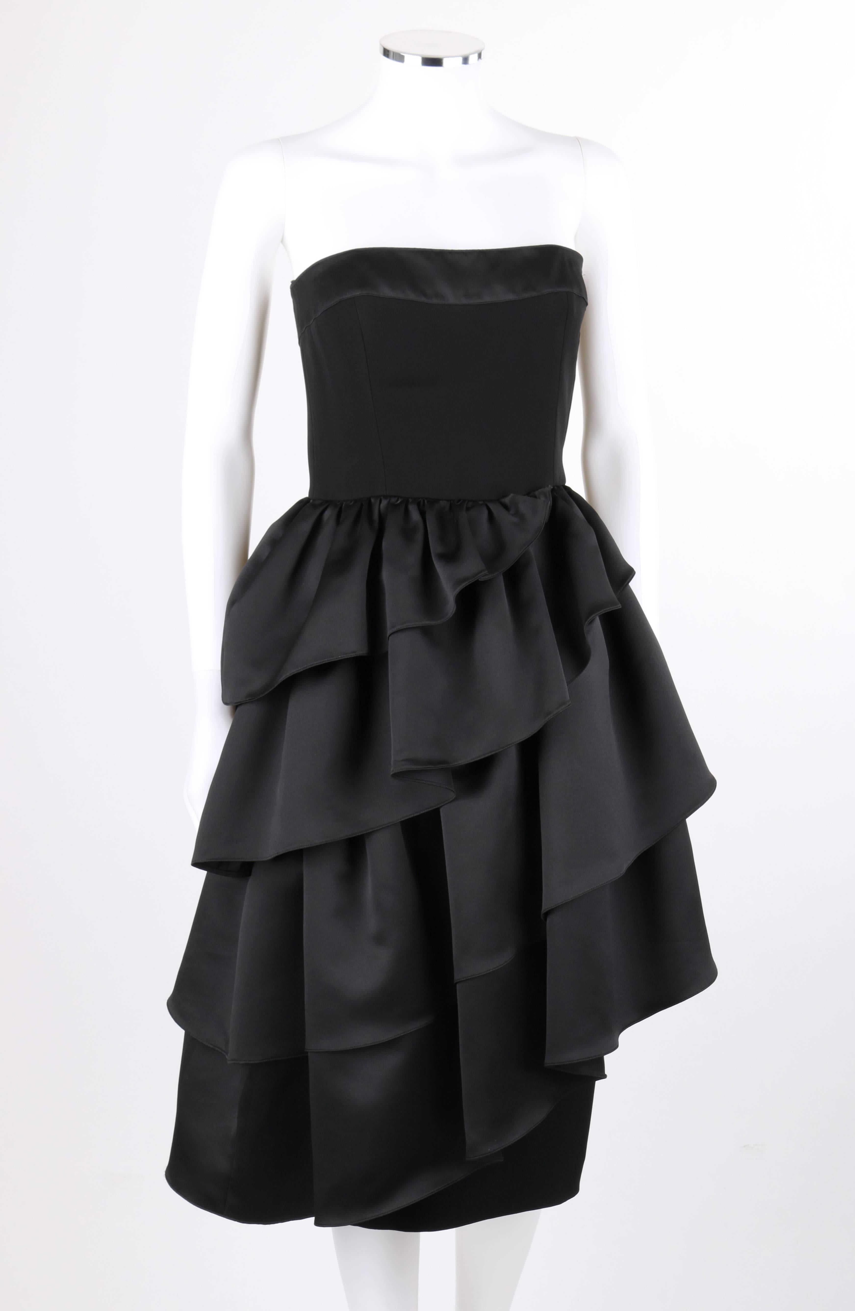 Vintage Louis Feraud c.1980's black asymmetrical tiered ruffle cocktail dress. Black satin asymmetrical ruffle four tier over skirt. Matte shift under skirt with right side seam slit. Strapless bodice with contrasting satin band along top. Left side