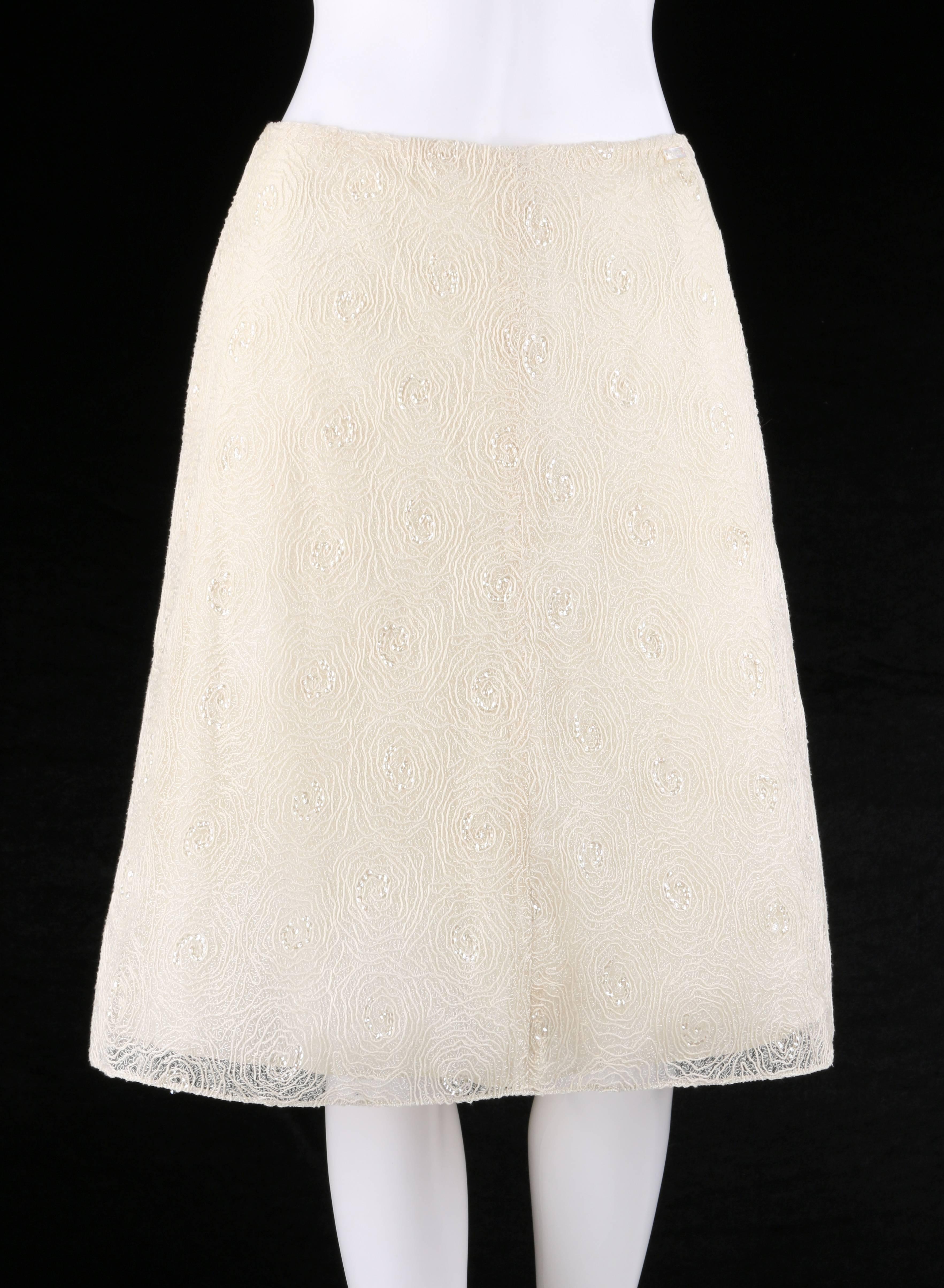 Chanel Spring/Summer 2002 cream floral embroidered sequin embellished tulle skirt designed by Karl Lagerfeld. Swirled floral embroidery over tulle net with clear sequin embellishment at center of flowers. Mother of pearl rectangular 