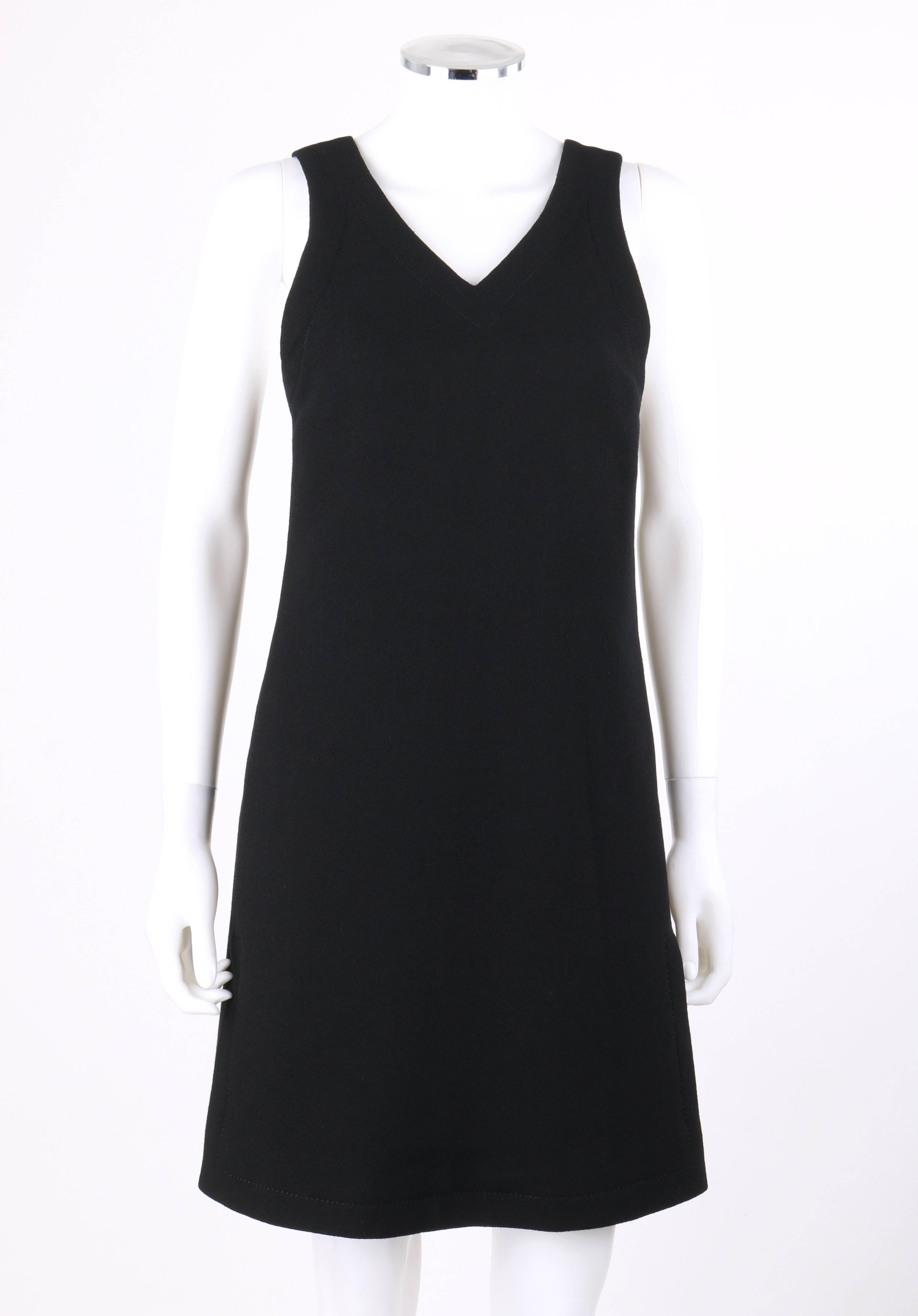 Vintage Jean Patou c.1960's Haute Couture numbered (89737) black wool v-neck jumper dress. Designed by Michel Goma. V-neckline. Sleeveless. Thin shoulder straps with single black button closure at back. Shift jumper style. Two side seam knife pleats