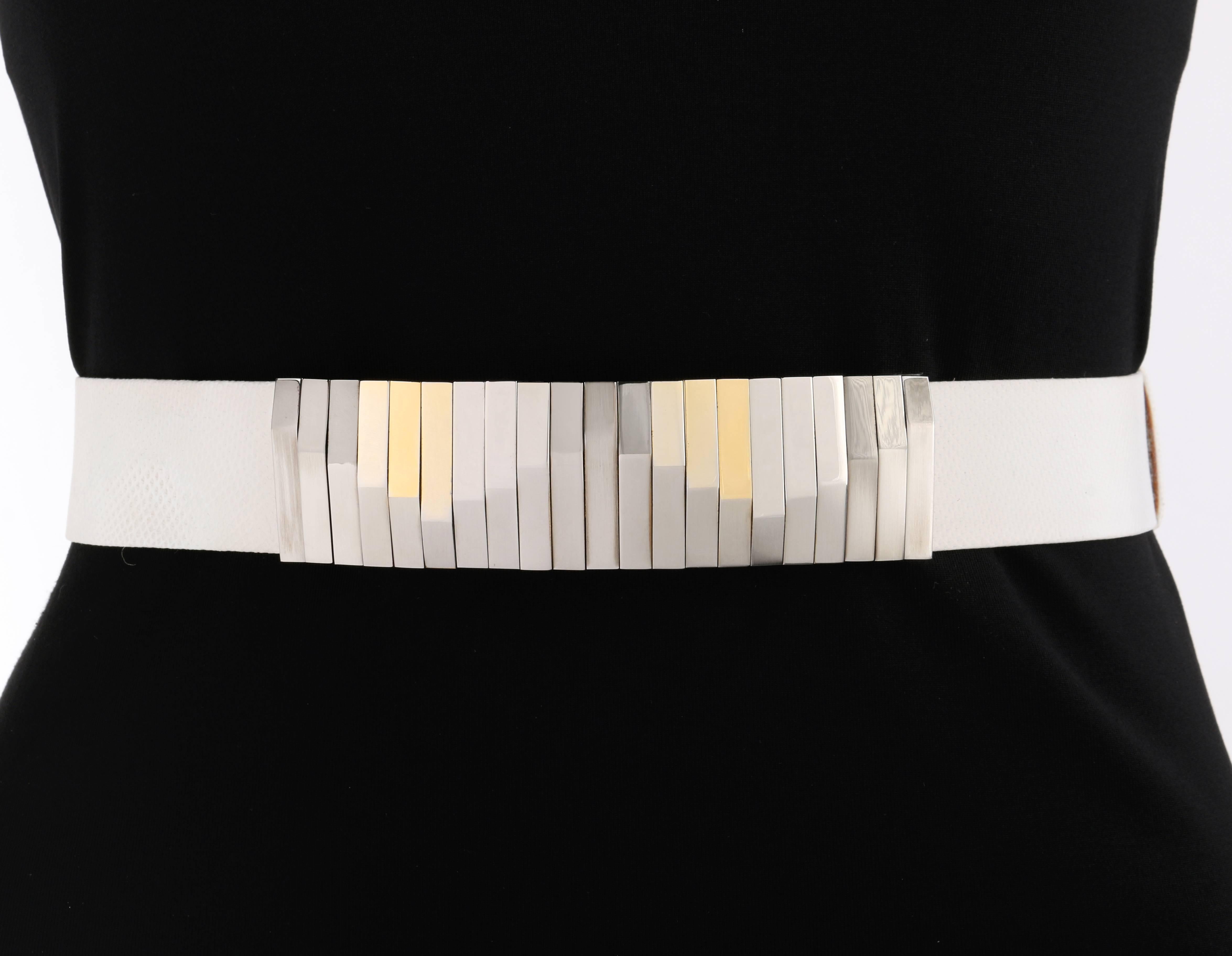 Vintage Judith Leiber c.1980's white lizard skin / leather statement waist belt. White lizard skin leather adjustable sliding body. Two-tone silver and gold-toned metal geometric rectangular buckle. Belt fastens with single center front hook and