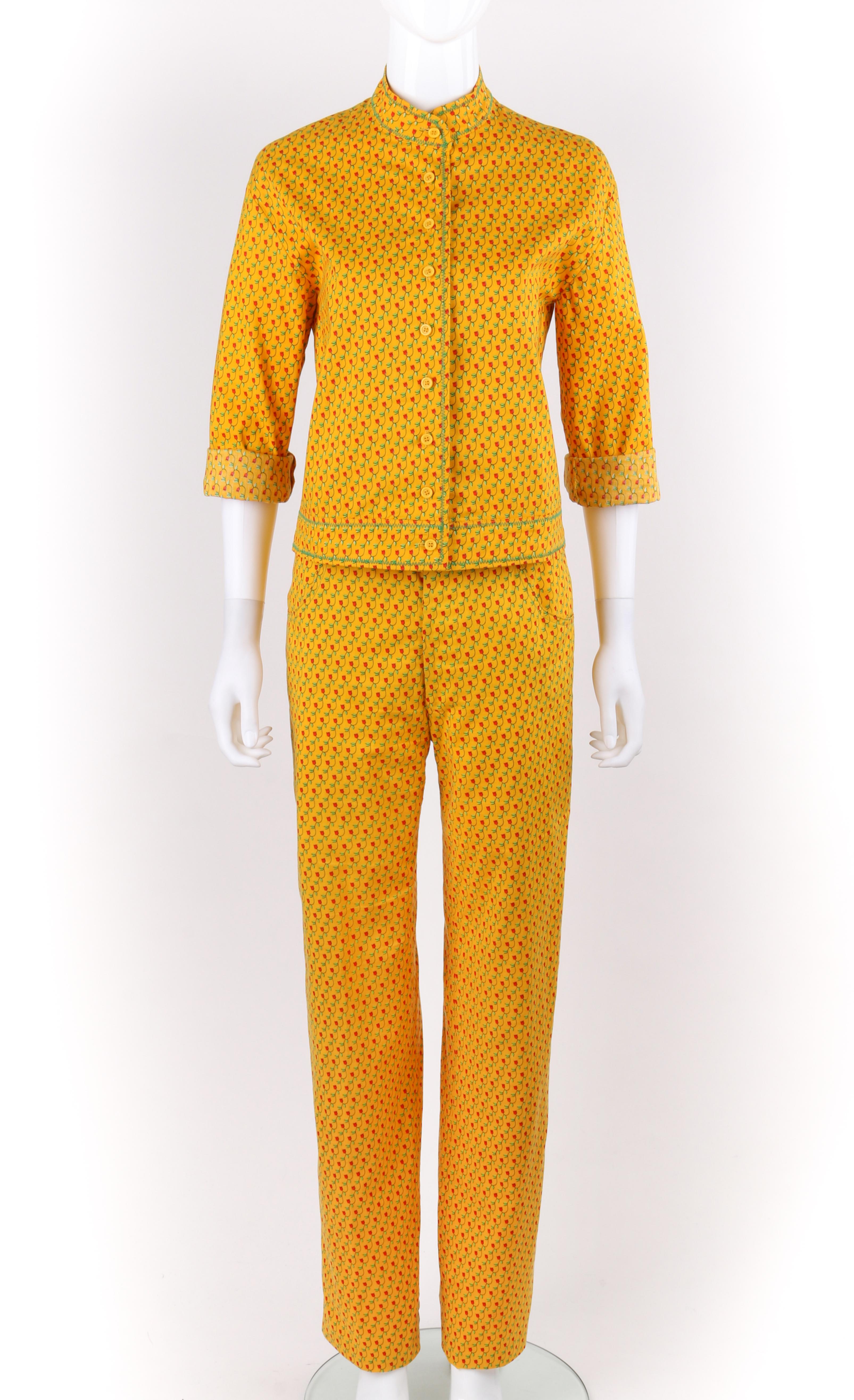 DESCRIPTION: ANNE KLEIN c.1970's 2 Pc Marigold Floral Tulip Button Down Shirt Pants Suit Set
 
Circa: c.1970’s
Label(s): Anne Klein; Union Label 
Designer: Donna Karan
Style: Pant suit
Color(s): Marigold yellow, green, black, and red
Lined: