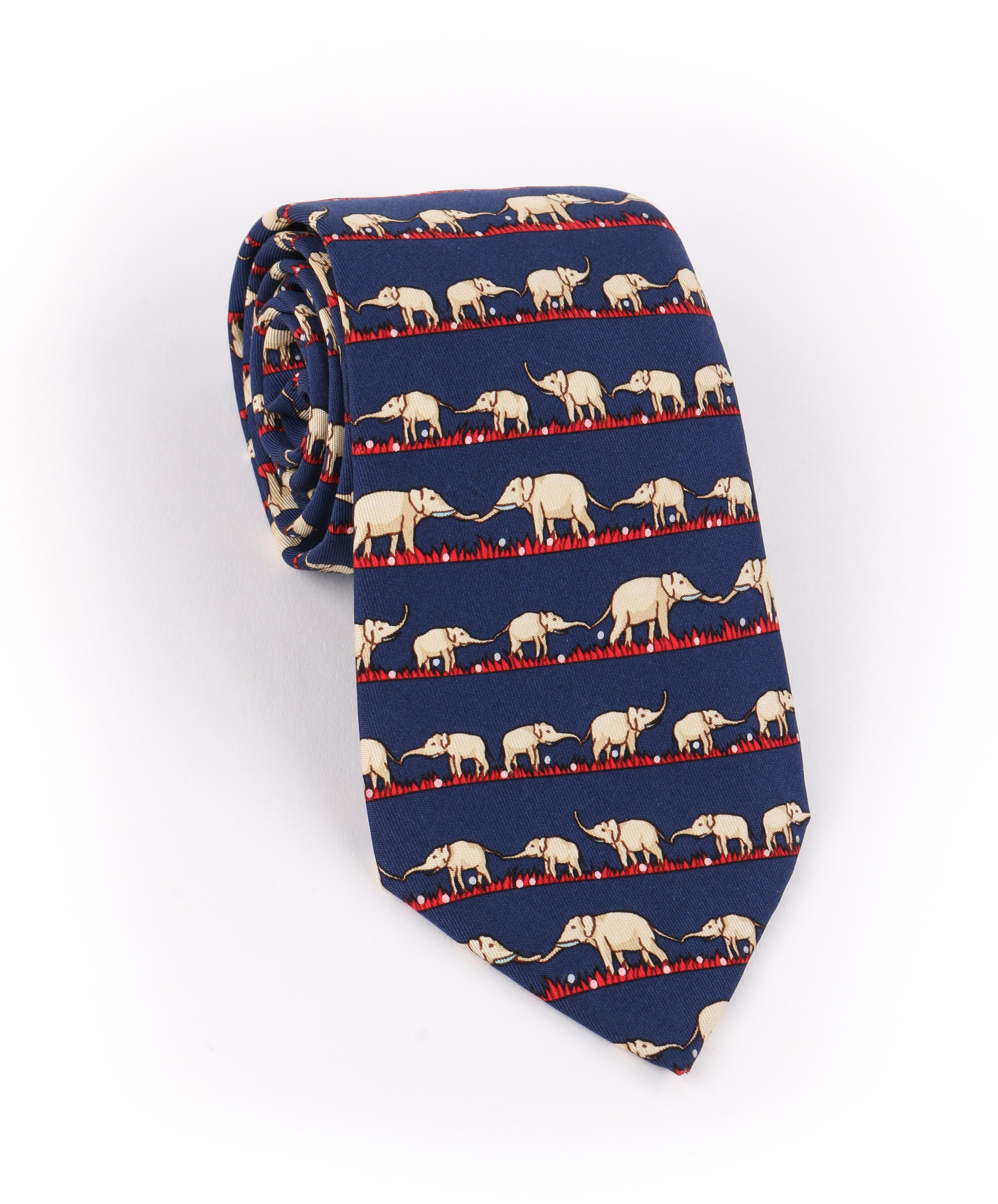 DESCRIPTION: HERMES Navy Blue & Red Elephant Family Print 5 Fold Silk Necktie Tie 7621 TA
 
Brand / Manufacturer: Hermes
Collection: 
Designer: 
Manufacturer Style Name: 
Style: 5 fold necktie
Color(s): Multi in shades of navy blue, beige, gray,