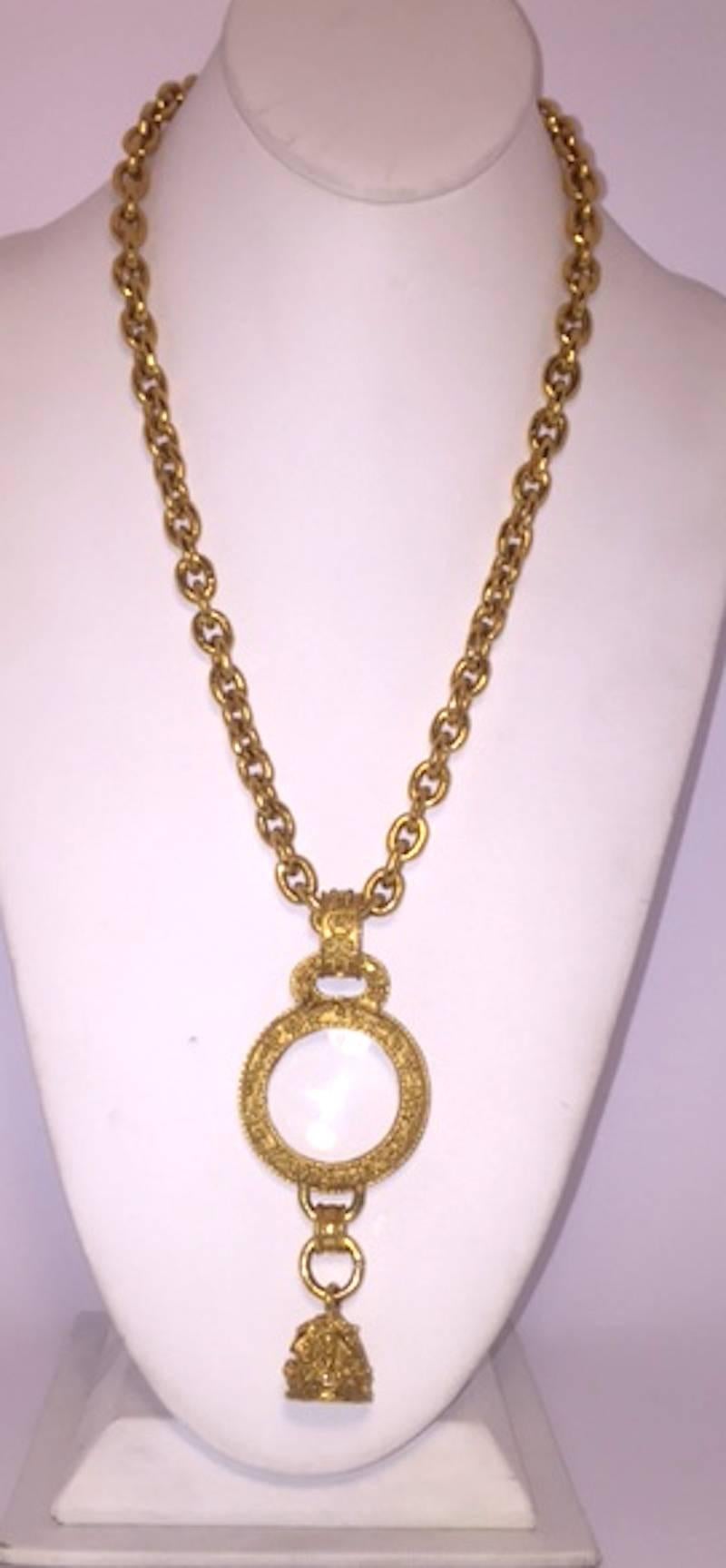 From the Chanel Autumn 1994 collection. Heavy chain with clasp length is 35.5 inches (90 cm.) long. Magnifying glass pendant with bell charm. From top of bail to bottom of bell the pendant measures 4.25 inches (12 cm.) long and 1.75 inches (4.5 cm.)