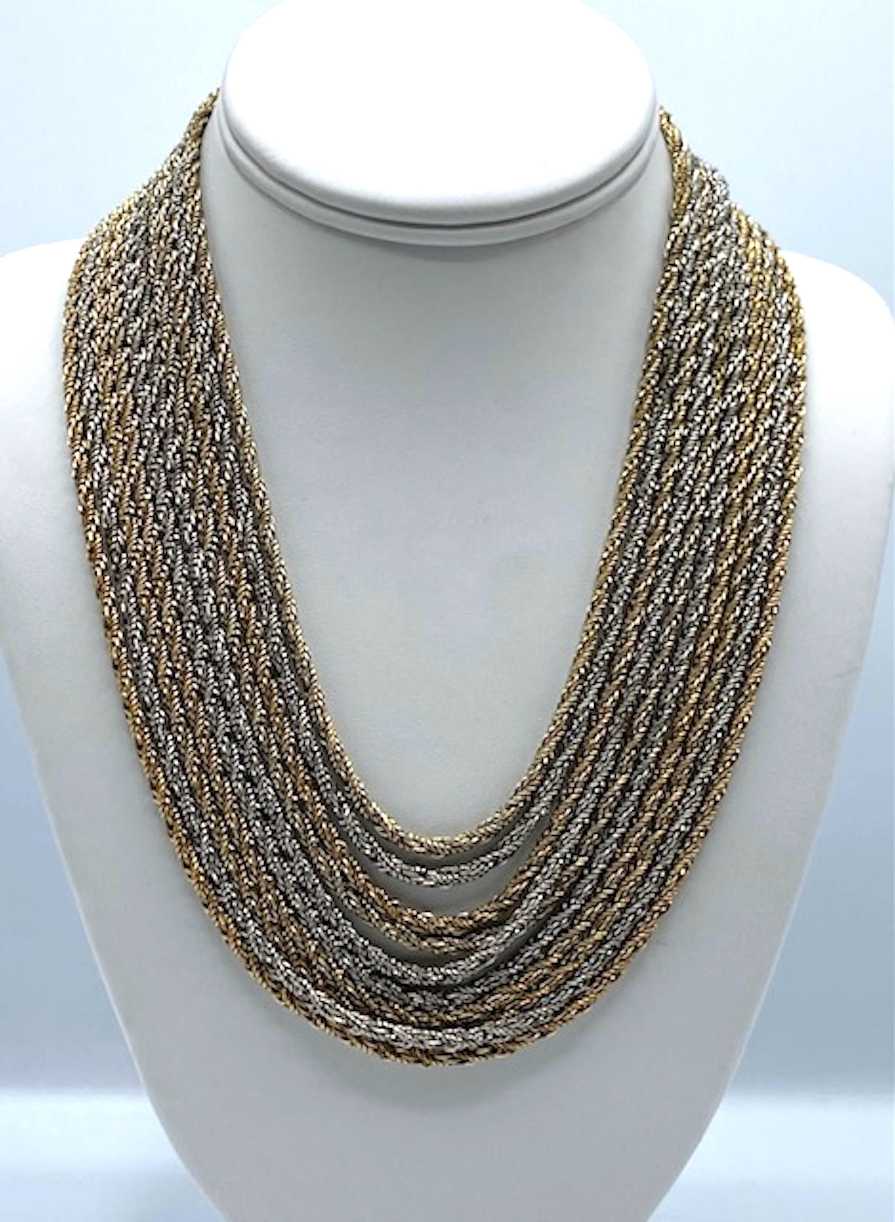 Questa straordinaria collana vintage di Christian Dior, realizzata dalla stimata Henkel & Grosse for Christian Dior, è caratterizzata da 10 fili fluidi di maglie di corda intrecciate con placche d'oro e d'argento alternate, che creano una