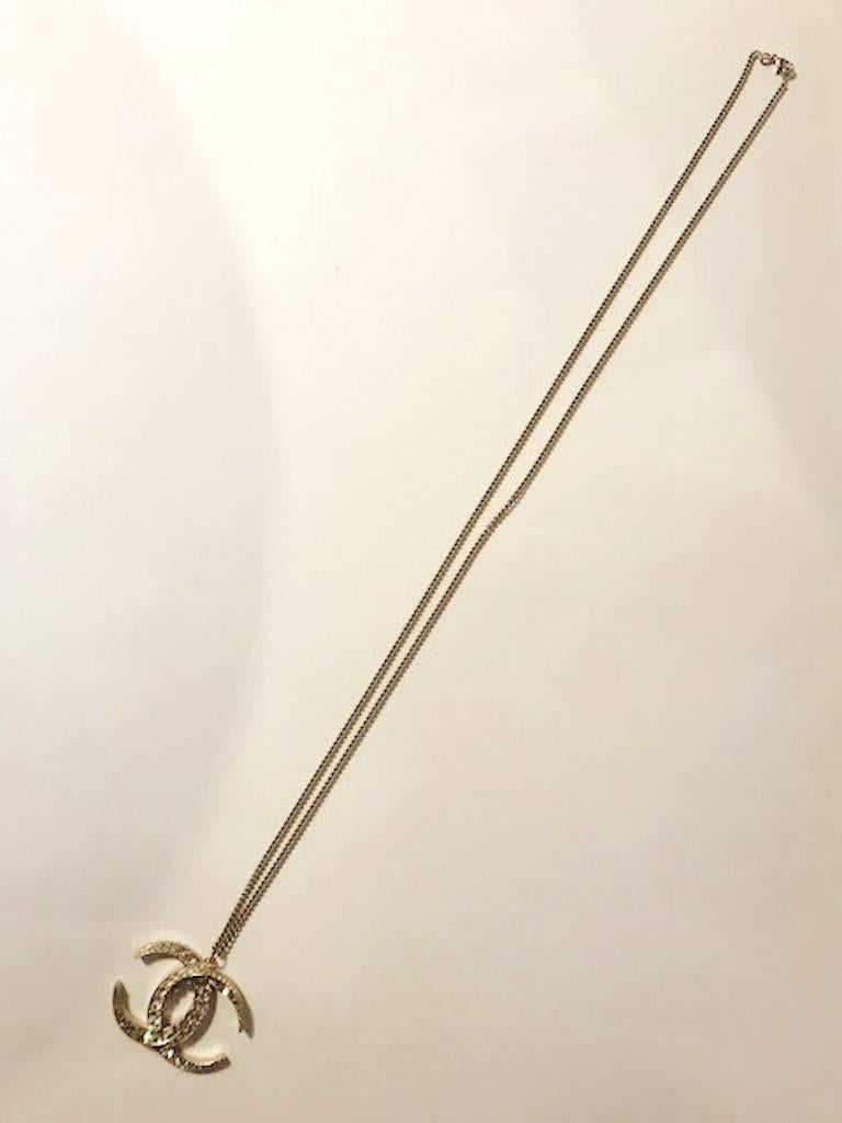 Chanel 2015 cruise collection double C pendant necklace in pale gold with clear and champagne color rhinestone crystal. The double C logo of Chanel was created by her good friend and jeweler Duke Fulco di Verdura. Verdura worked for Chanel from 1927