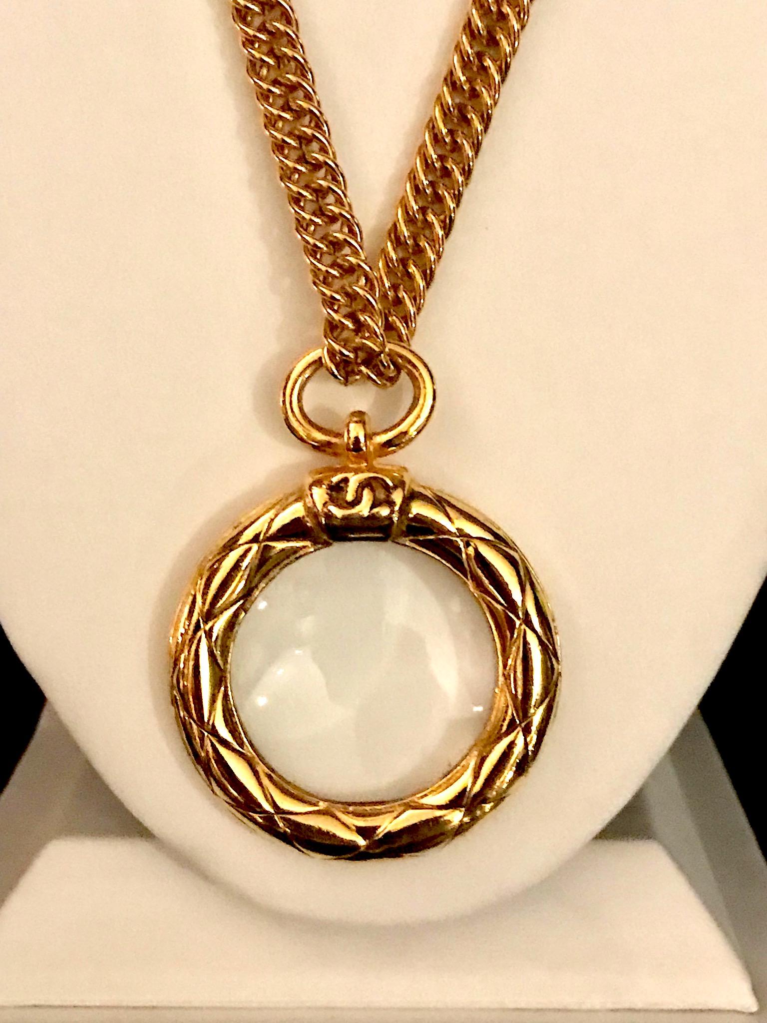 An iconic Chanel quilt frame magnifying glass pendant necklace from the early 1980s. The pendant has a glass magnifying lens set into the round quilt frame and measures 2