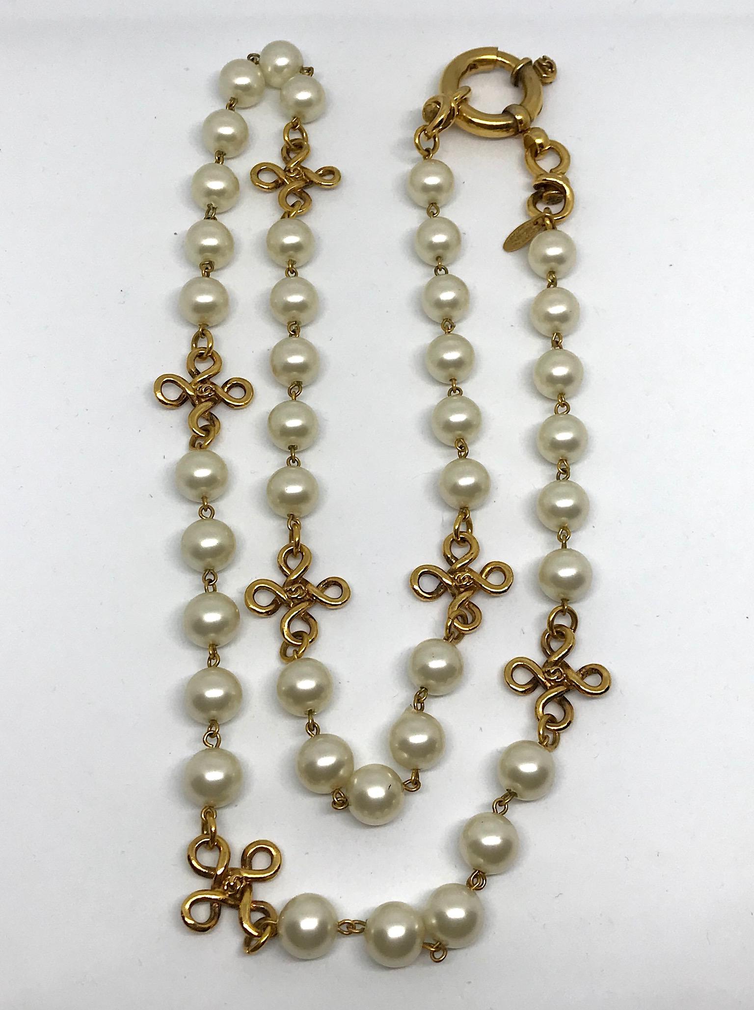 A lovely necklace of Chanel's iconic long strand of faux pearls interspersed with six gold loop accents. Total length of 36.25 inches. Pearl beads are glass center and measure about 10 mm. The gold four loop spaces are 7/8