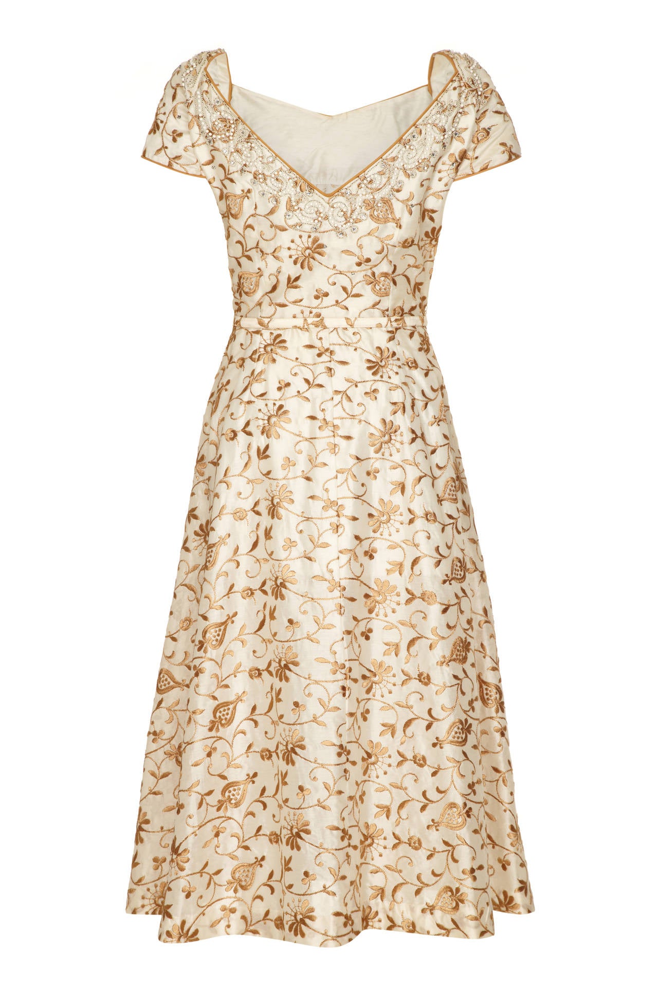 Absolutely beautiful cream and gold floral brocade silk dress by Kramer with exquisite beading, embroidery and rhinestone detail around the neckline.  The dress features pretty cap sleeves, sweetheart neckline with deep V to the back and original