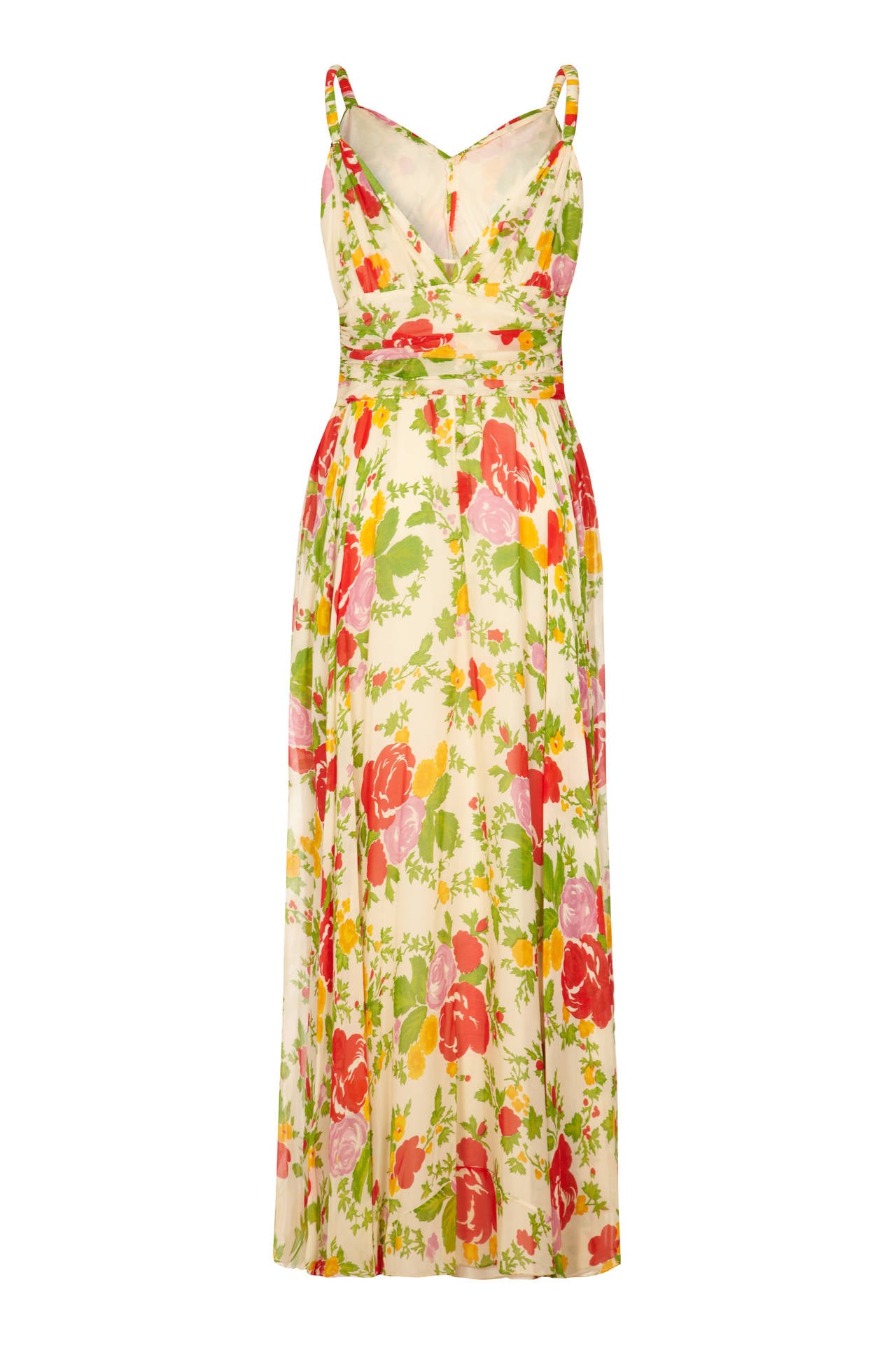 Stunning 1930s full length cream silk chiffon dress with beautiful red, green and yellow floral print.  This piece features a gathered chiffon band to the waist, twisted straps, pretty, low V to the back and is fully lined.  A beautiful dress for