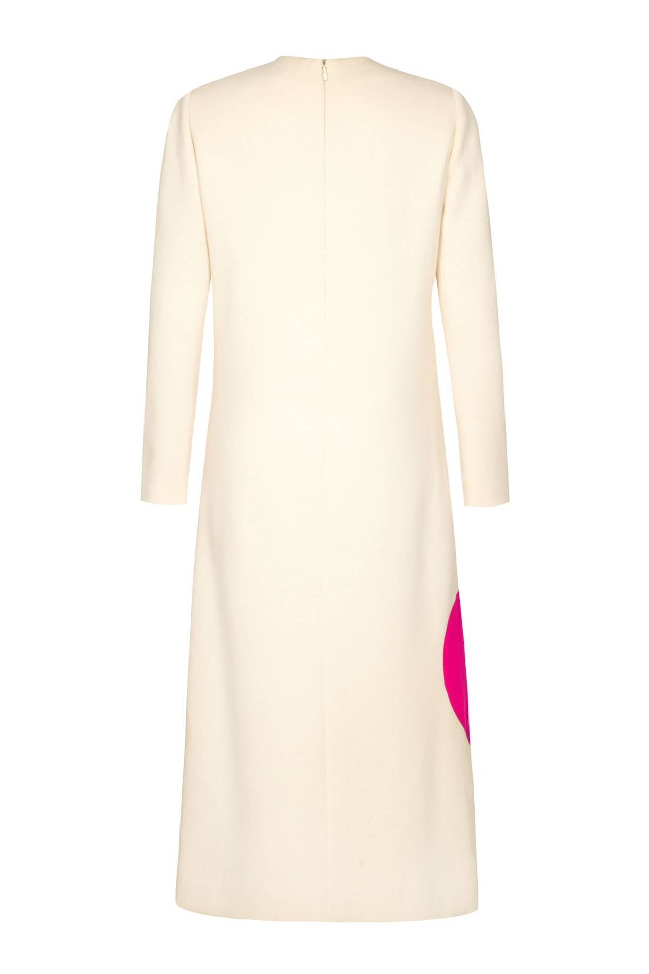 Iconic 1960s wool space age dress by Pierre Cardin.  This cream straight cut, calf length example features long sleeves with bold purple and green stripes to the front and bright pink circle to the side. Fully lined in a soft cream silk lining it is