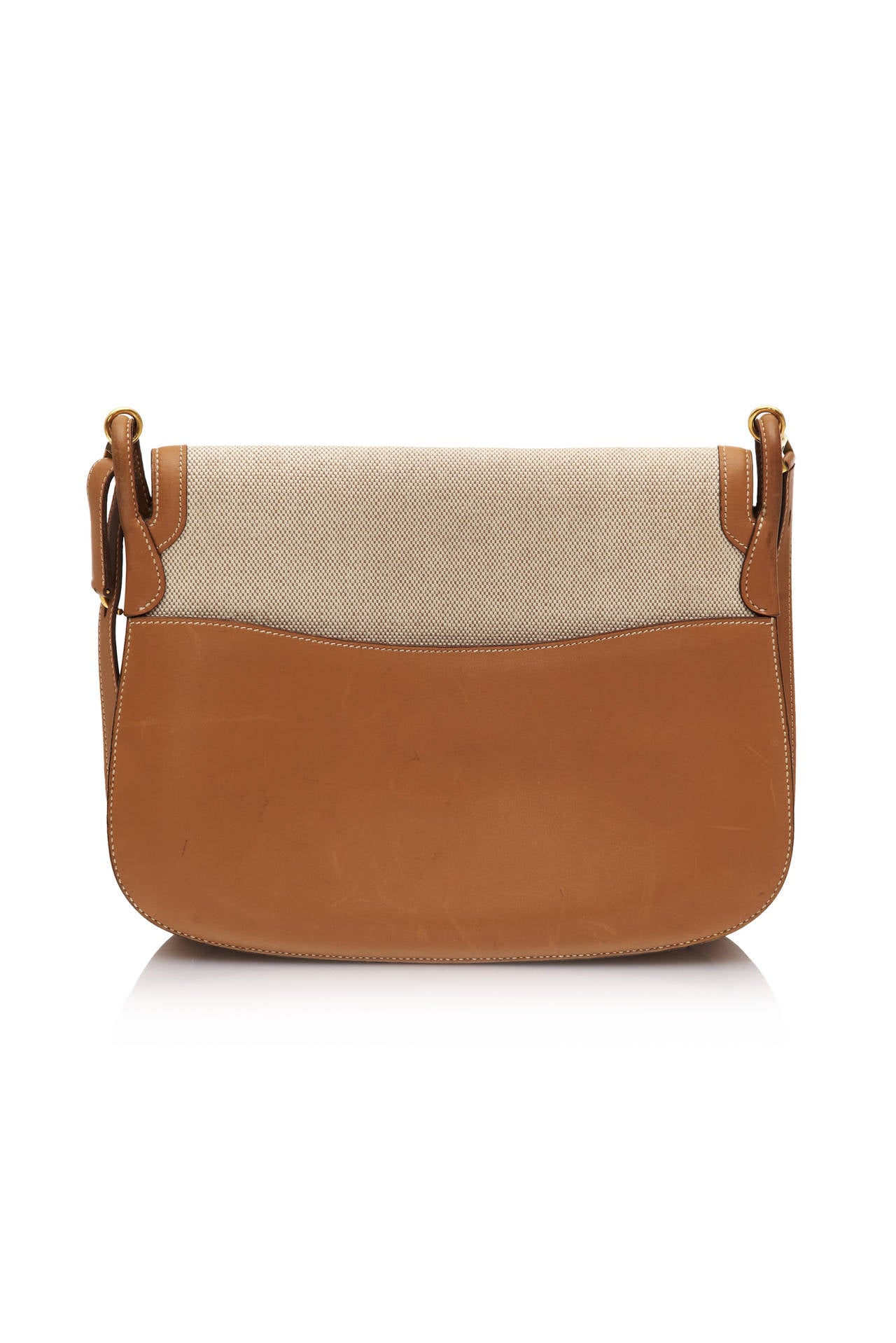 Beautiful handbag by Hermes with beige linen body, pale brown leather strap and details and gold tone metal clasp to fasten.  It features a pocket at the back in brown leather and three interior pockets, one with zip fastening.  A very collectable