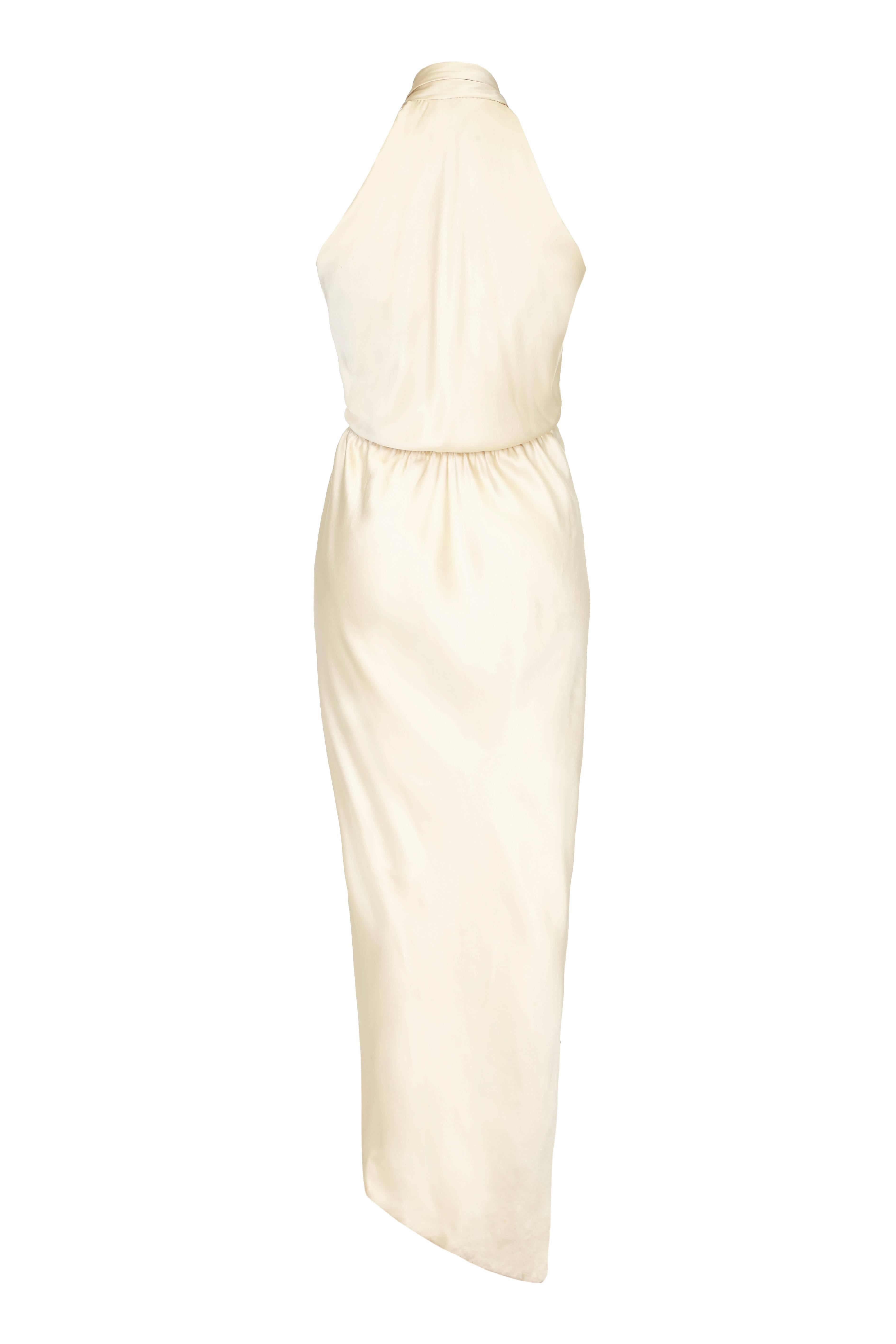 Incredible vintage 1970s Halston dress in soft flowing cream silk with asymmetrical wrap skit, cross over front and halter neck with bow detail.  This iconic piece would make a gorgeous option for a non traditional wedding dress or for any other