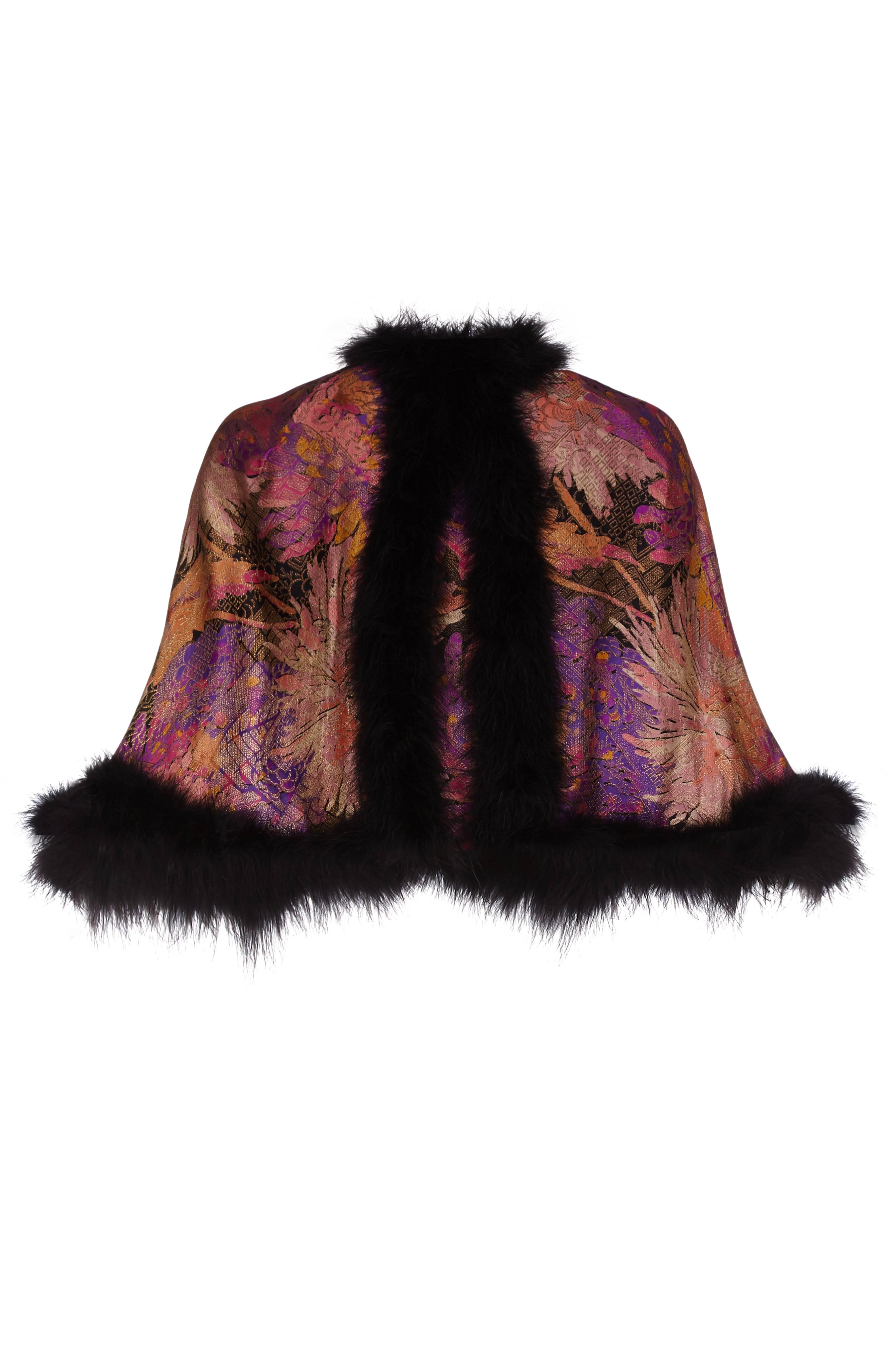 Gorgeous vintage 1920s pink,purple and black lame cape with black feather trim and gold frogging fastening. This versatile piece has a very oriental feel and would make a lovely accessory for an evening out.  It is in excellent vintage condition