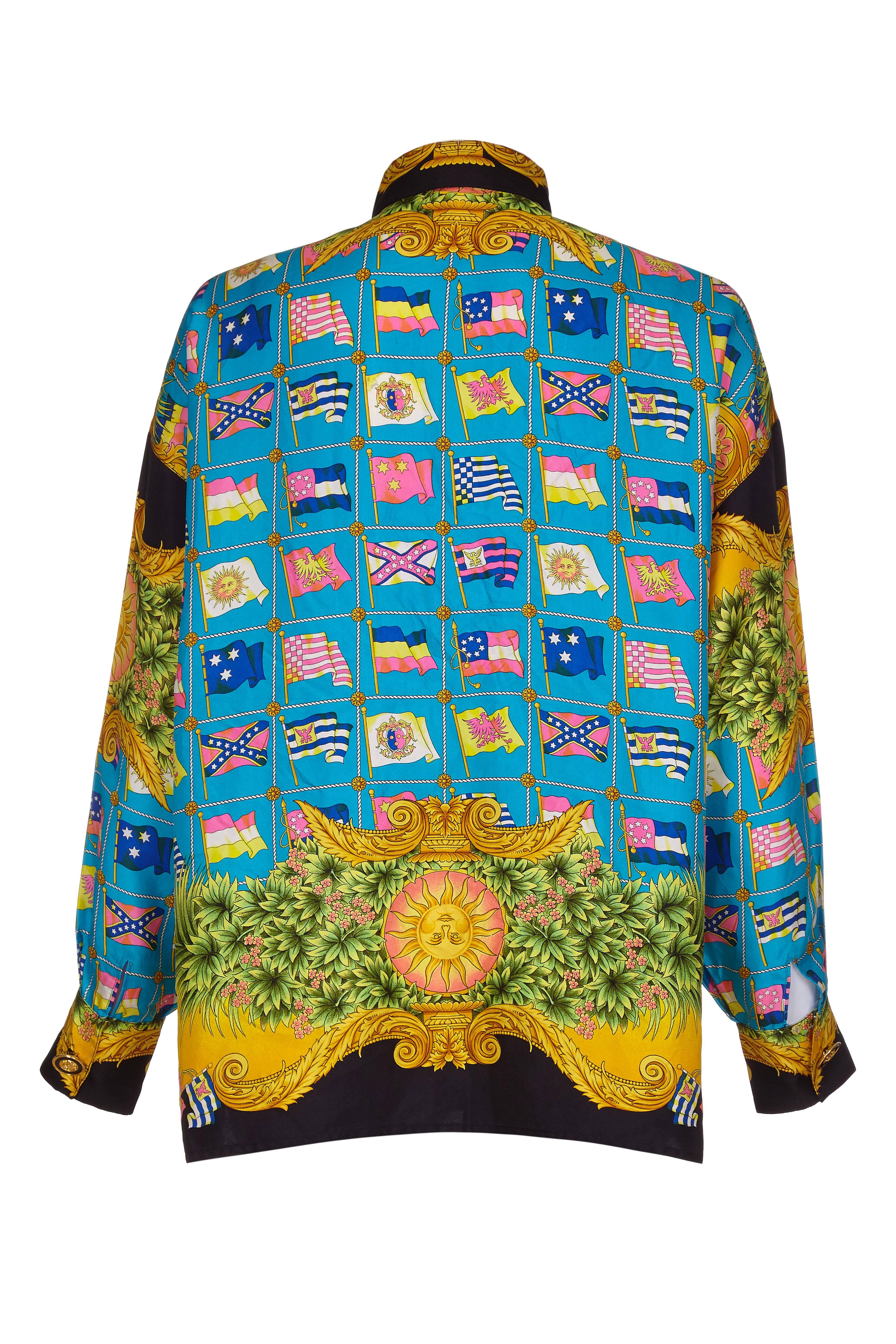 A super example of a Gianni Versace colourful baroque print silk shirt.  This one dates to the mid 1990s and features a colourful sun print and stylised flags.  The shirt has decorative medusa buttons on the cuffs and top button - the rest of the