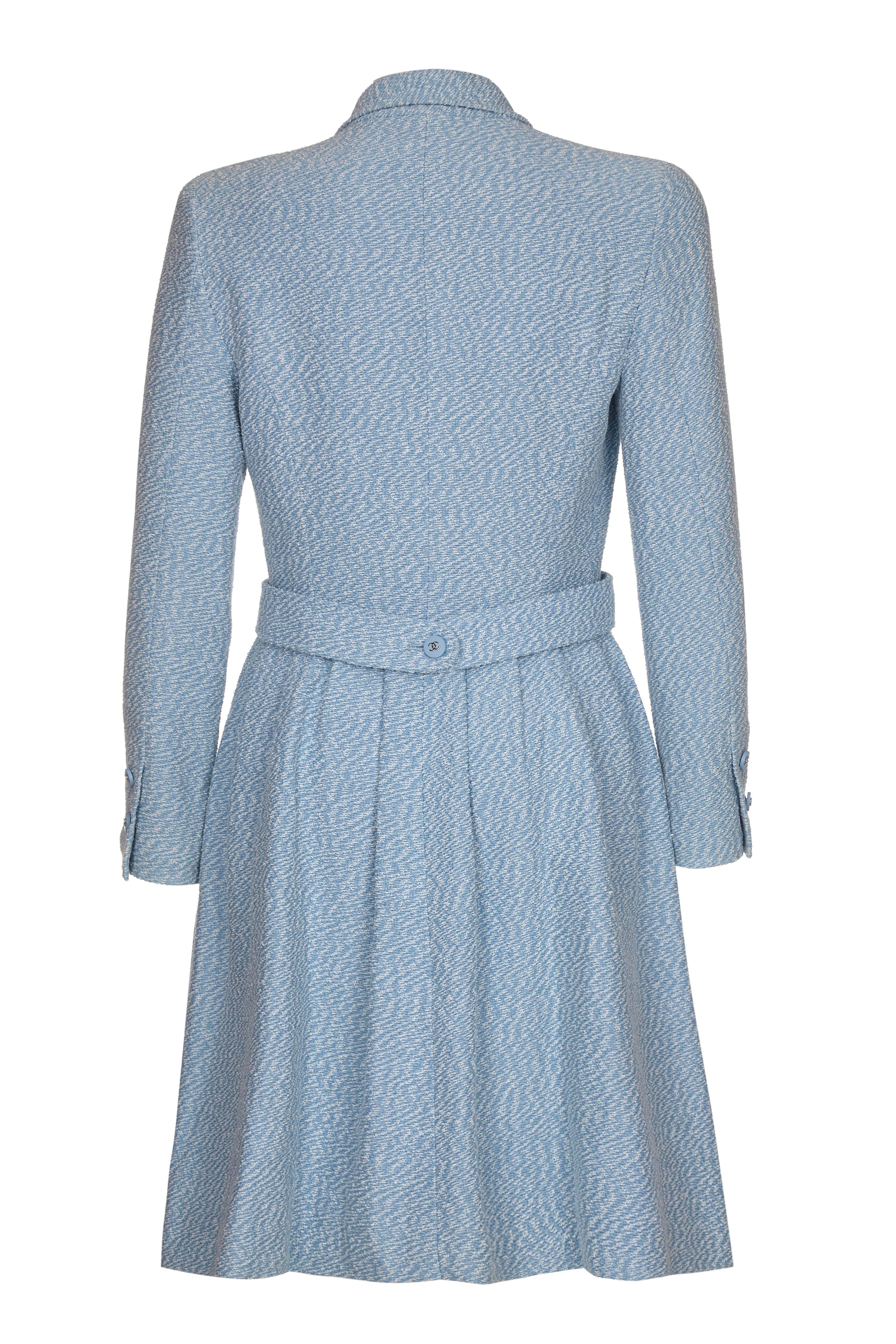 Lovely vintage pale blue tweed Chanel dress coat dating from 1996. This piece is double breasted and fastens with CC logo buttons in a matching pale blue, with a branded pale blue silk lining inside. The skirt is pleated from the hip and around the