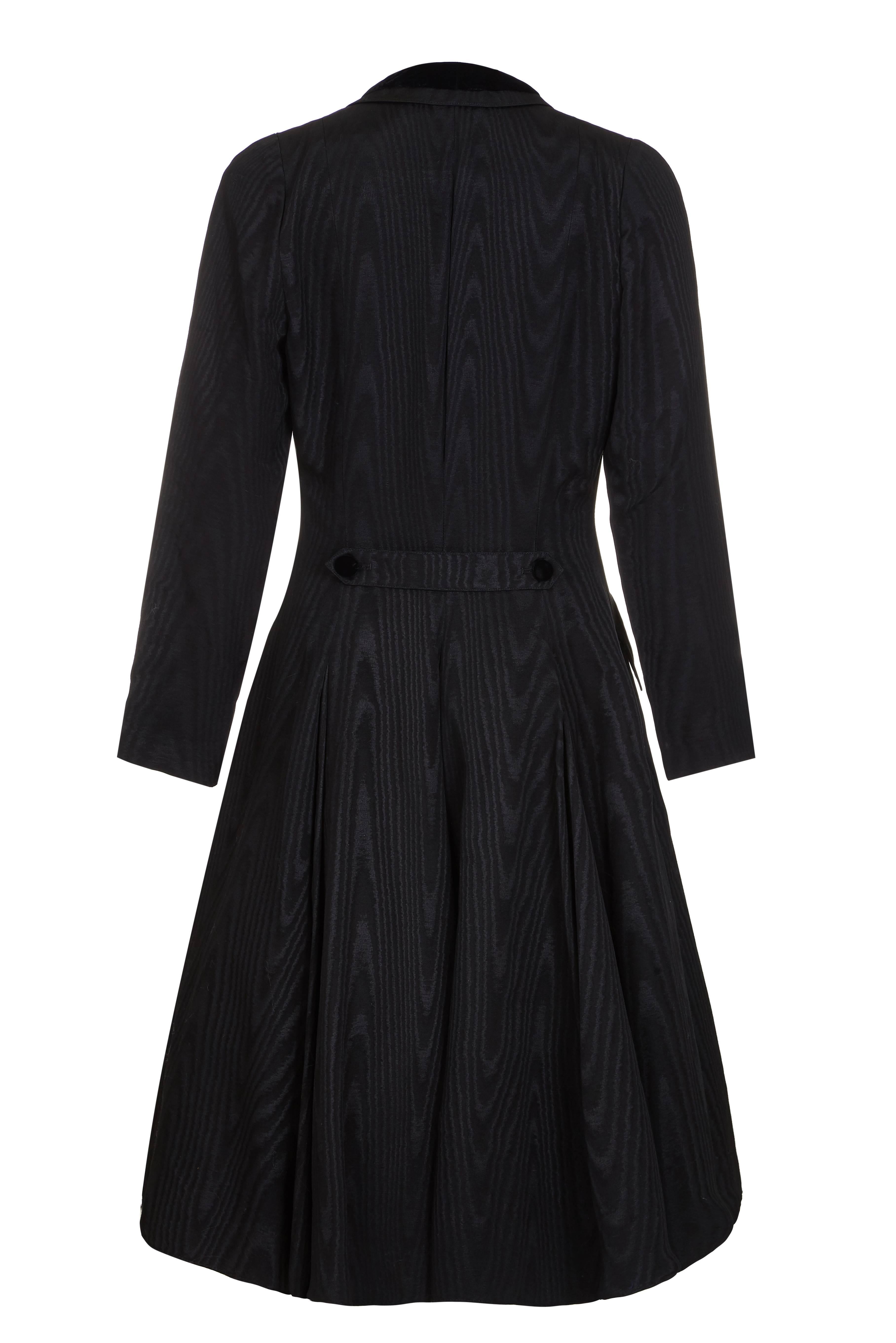 Very theatrical 1980s Louis Feraud black moire (watered) fabric dress in the style of a Victorian riding coat.  Beautifully made and very fitted, the double breasted design features velvet buttons and trim on the neckline of the collar and pockets. 