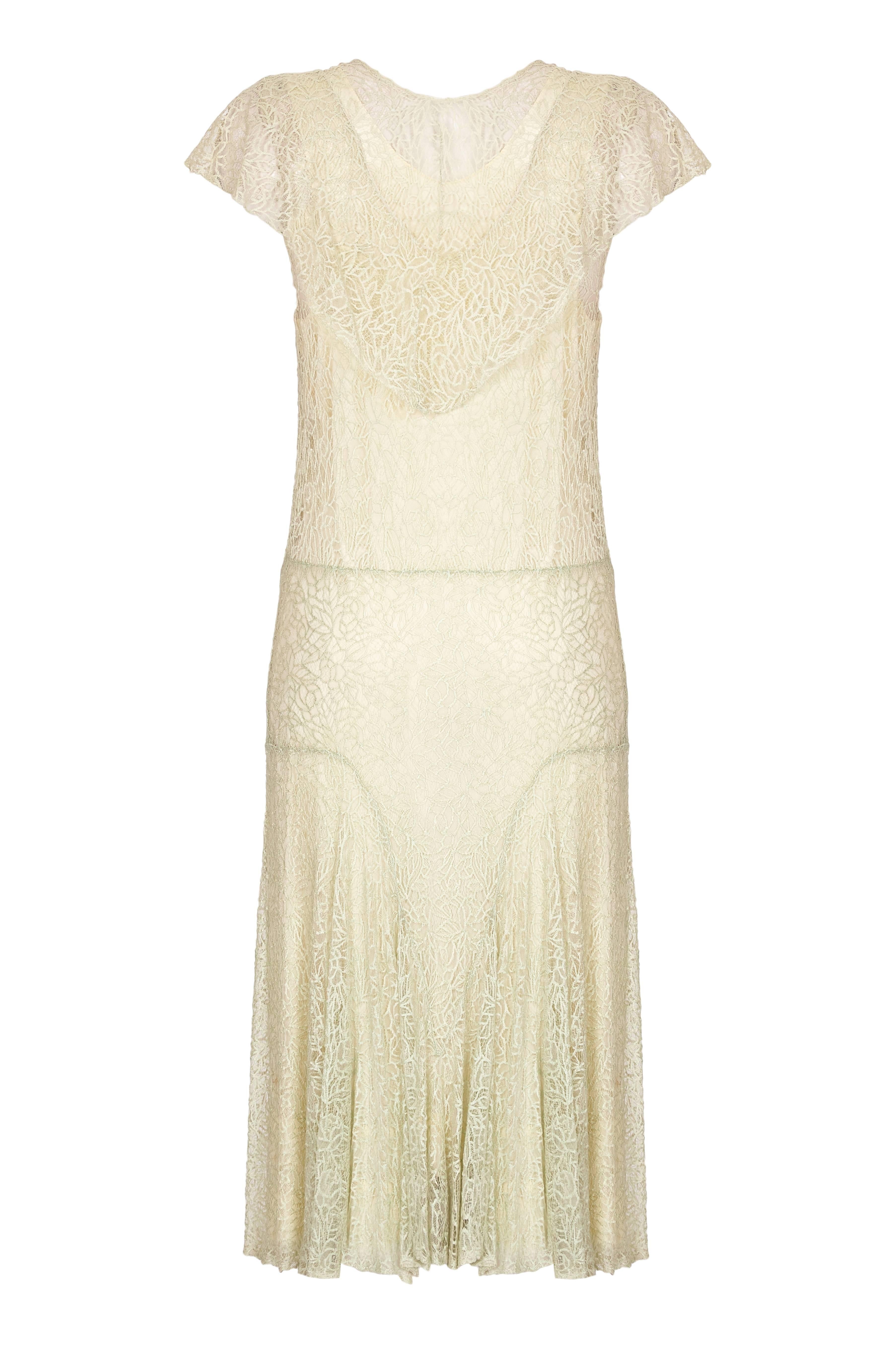 This lovely 1920s true flapper dress is in a very soft mint green shade and made from exquisite cobweb lace.  It is in excellent antique condition. Typical of this period, the waist line is dropped and not fitted.  With godet pleating from the