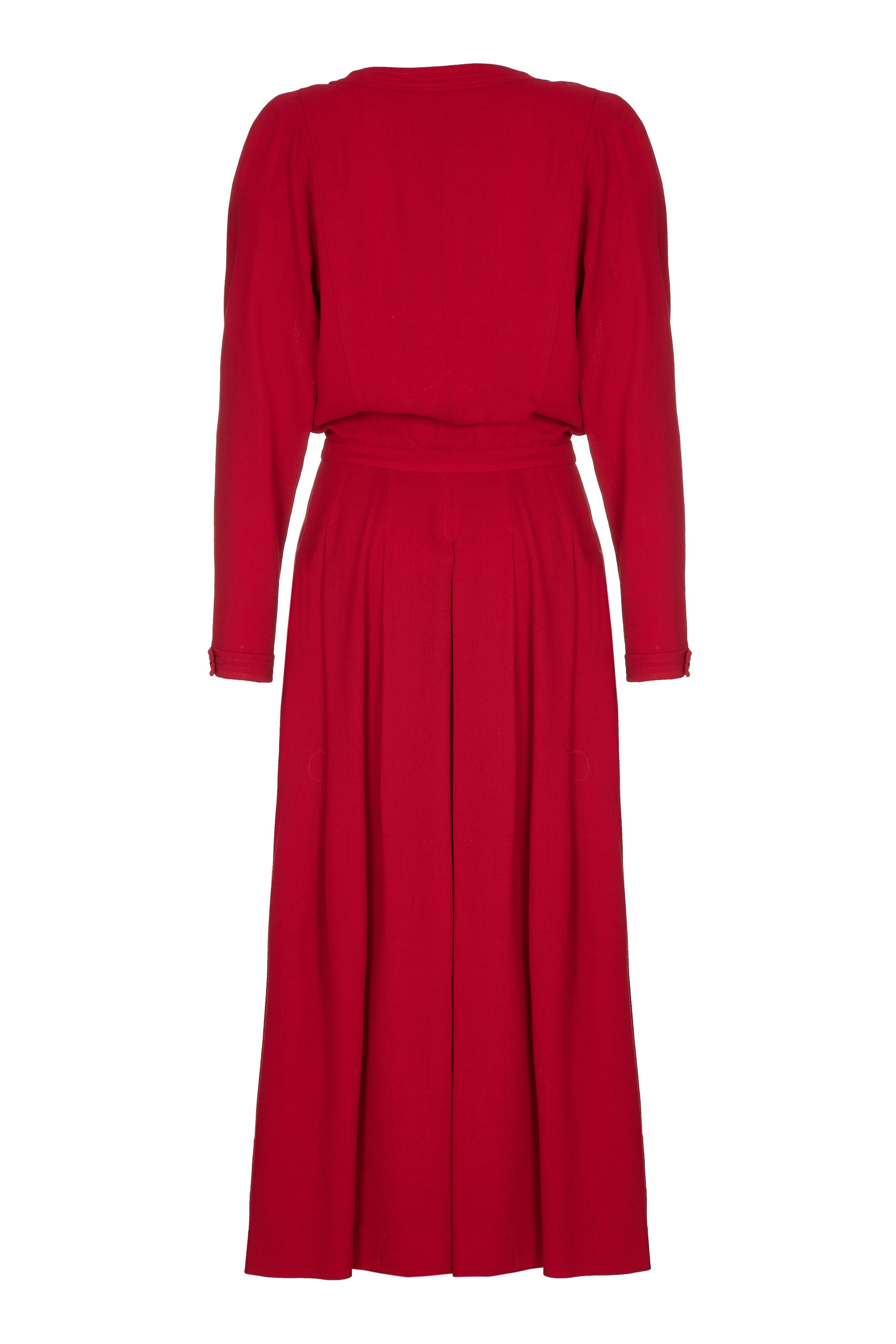 1980s Chanel double breasted red wool dress with gold buttons featuring the profile of the founder, Gabrielle Chanel. Although a looser fit on top it nips in at the waist and flares out to give the appearance of separates. Has full length sleeves