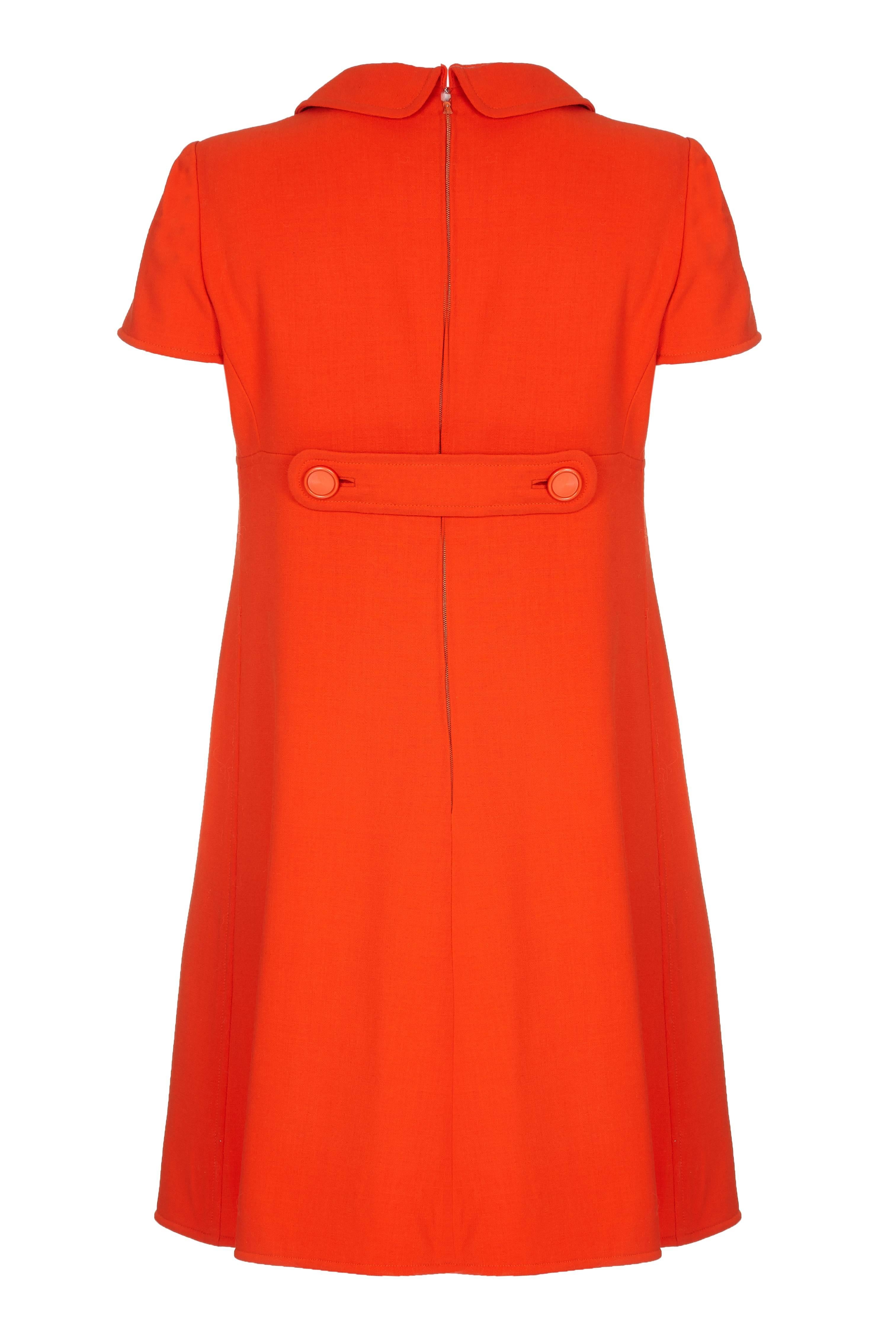 Late 1960s Courrèges wool shift dress in bright orange red with signature circular pocket detail. With cap sleeves and stylish peter pan collar this dress is beautifully cut and could be dressed up or down. Fully lined in what feels like cream silk