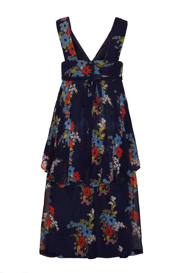 A stunning floaty summer dress from iconic British designer Ossie Clark. This classic 1970’s piece features a pretty floral print on layers of navy chiffon.  The print is by his wife and business partner Ceila Birtwell. Fitted around the bust with a