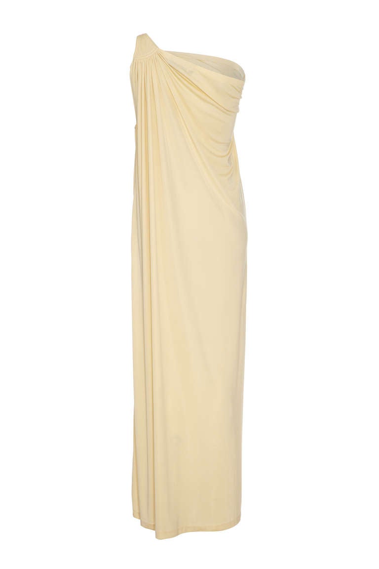 A stunning example of Yuki eveningwear, this cream jersey full-length gown is simple yet extremely elegant. The one shoulder, asymmetrical style is a classic from the era and this dress designed for manufacturer Rembrandt maintains the quality and