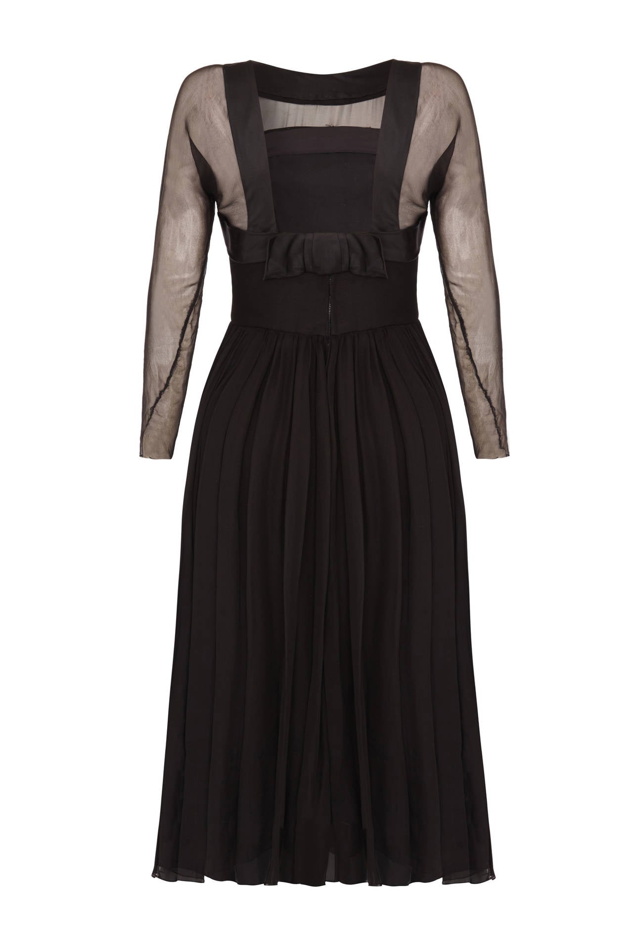 Early 1960s black chiffon dress by American evening wear designer Helena Barbieri.  This piece features a wide satin ribbon around the neckline and bust with a large bow at the back, where the neckline is cut low and square.  It has very pretty