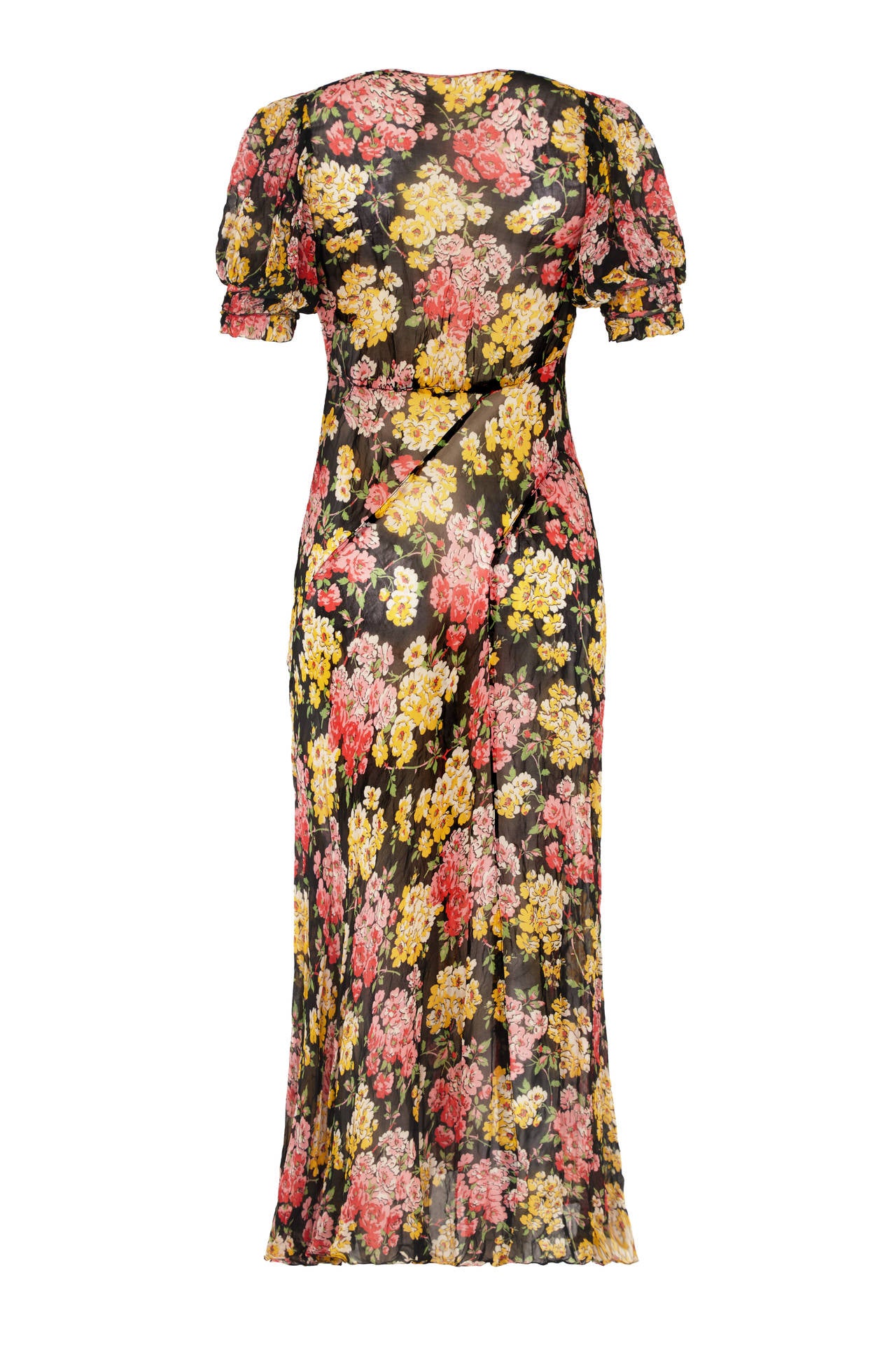 Beautiful bias cut chiffon dress with asymmetrical panels. This sheer and floaty summer dress features a pretty pink, yellow and green floral print on a black background and has a sailor style collar to the front and puff sleeves.  There are no