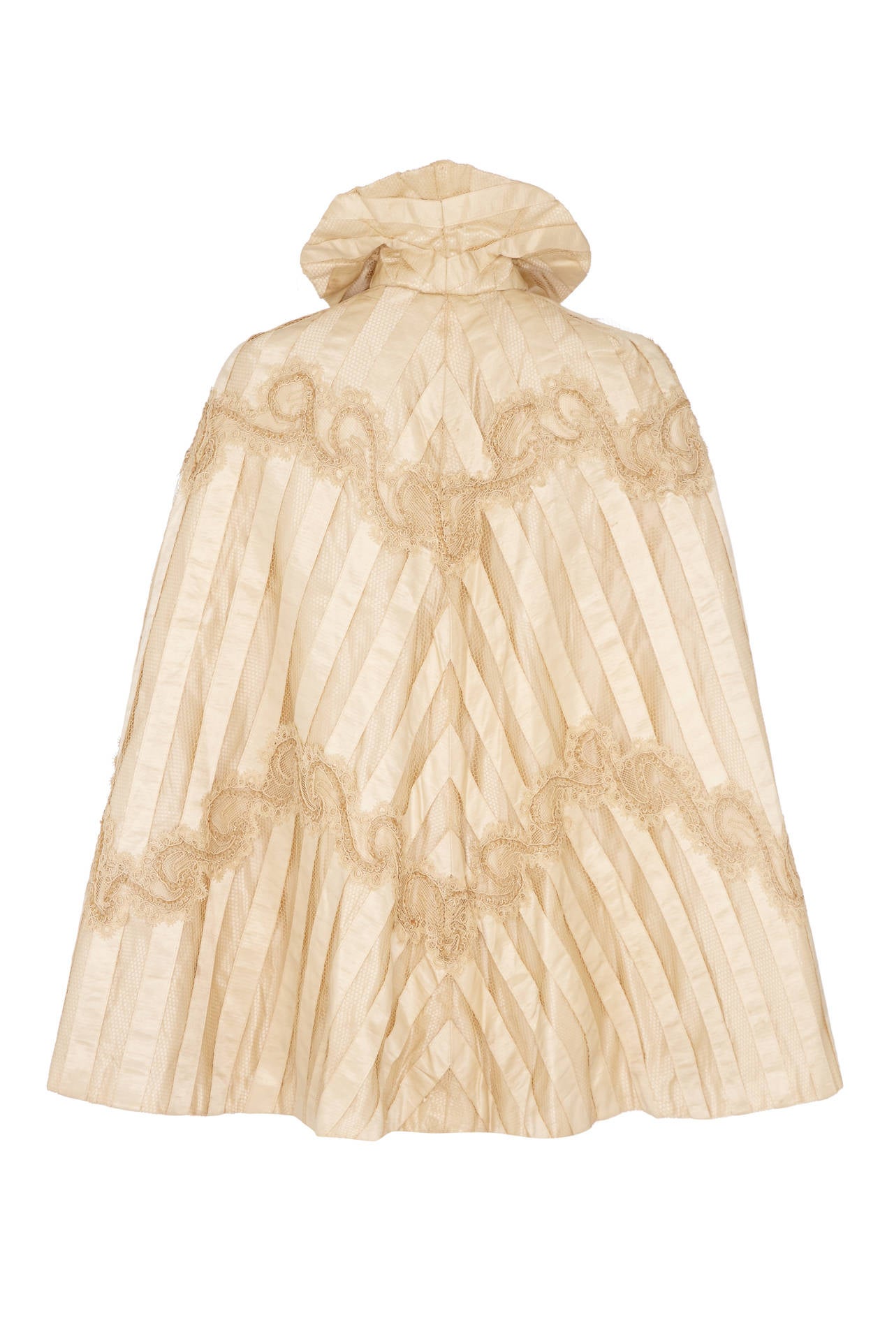 Beautiful cream silk cape dating from the 1880s consisting of stripes of silk ribbon and silk netting with an intricate corded and lace applique.  There are no makers labels but this is an outstanding piece and was most likely originally a wedding