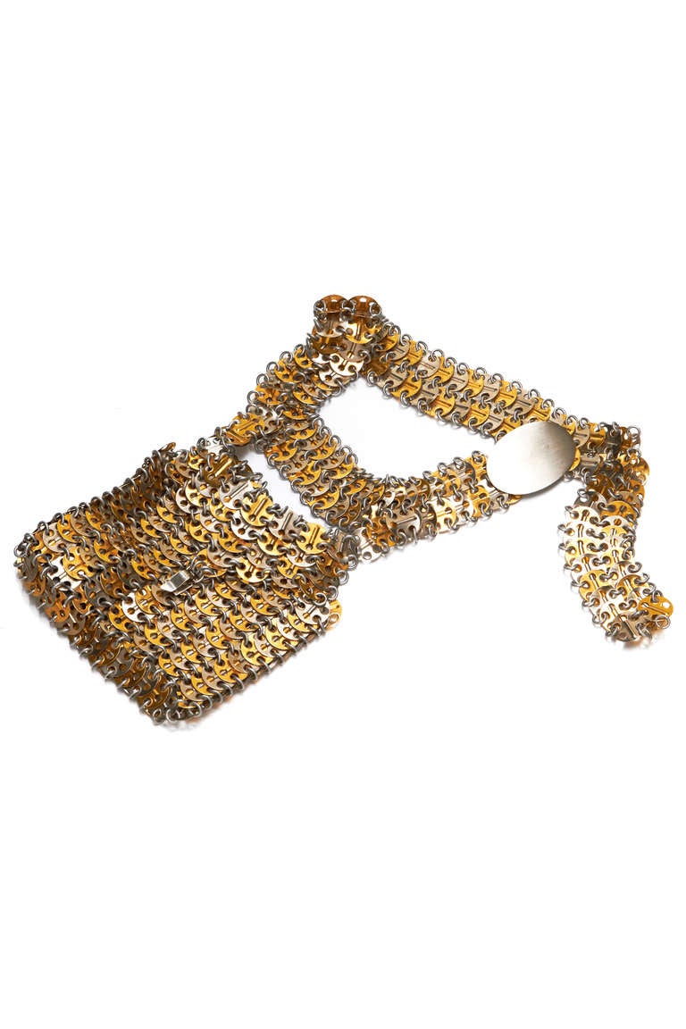 Fabulous vintage 1960's chain mail belt from Paco Rabanne with a small bag/ purse attached to one side.  This piece is made up of gold and silver tone metal discs linked together and fastens at the front with a large oval shaped silver tone plate
