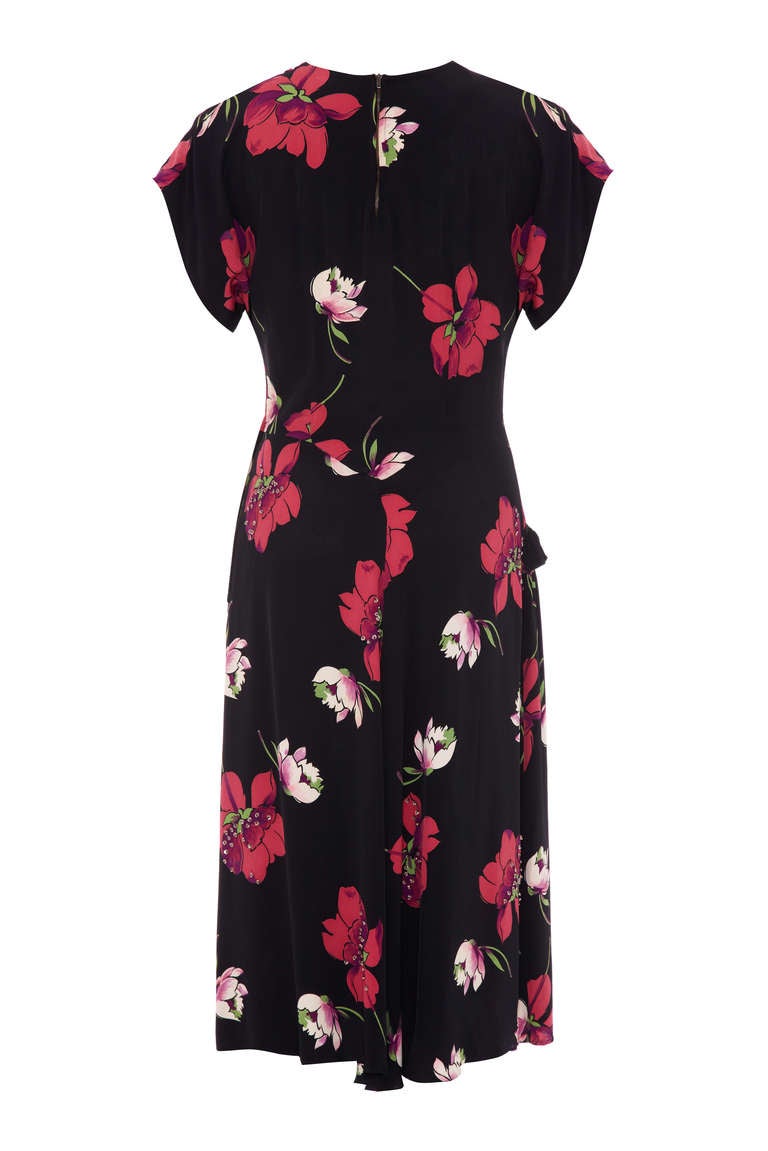 Really stylish and fun asymmetrically cut 1940’s day dress.  Made in a beautifully soft navy silky rayon with pink and white floral print and beading details. The dress is short sleeved with a small zip at the back of the neckline and a zip at the