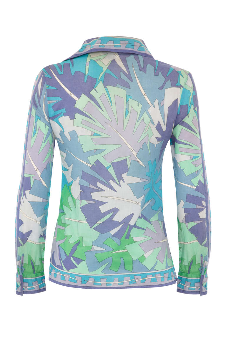 Classic 1960’s or early 1970s printed shirt from Emilio Pucci. Made up of a fine leaf printed cotton, shaded in blue, green and purple with tiny ‘Emilio’ signatures throughout. It fastens at the cuffs and down the front with covered buttons in the